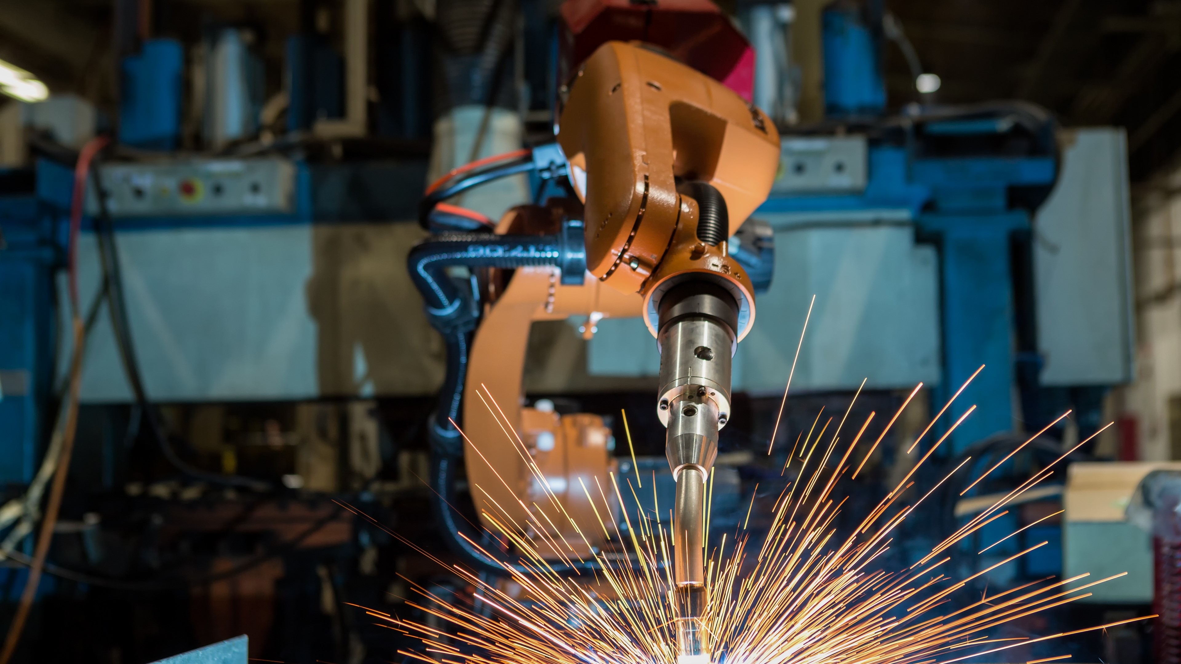 Robotic arm performing welding in a factory HD Wallpaper