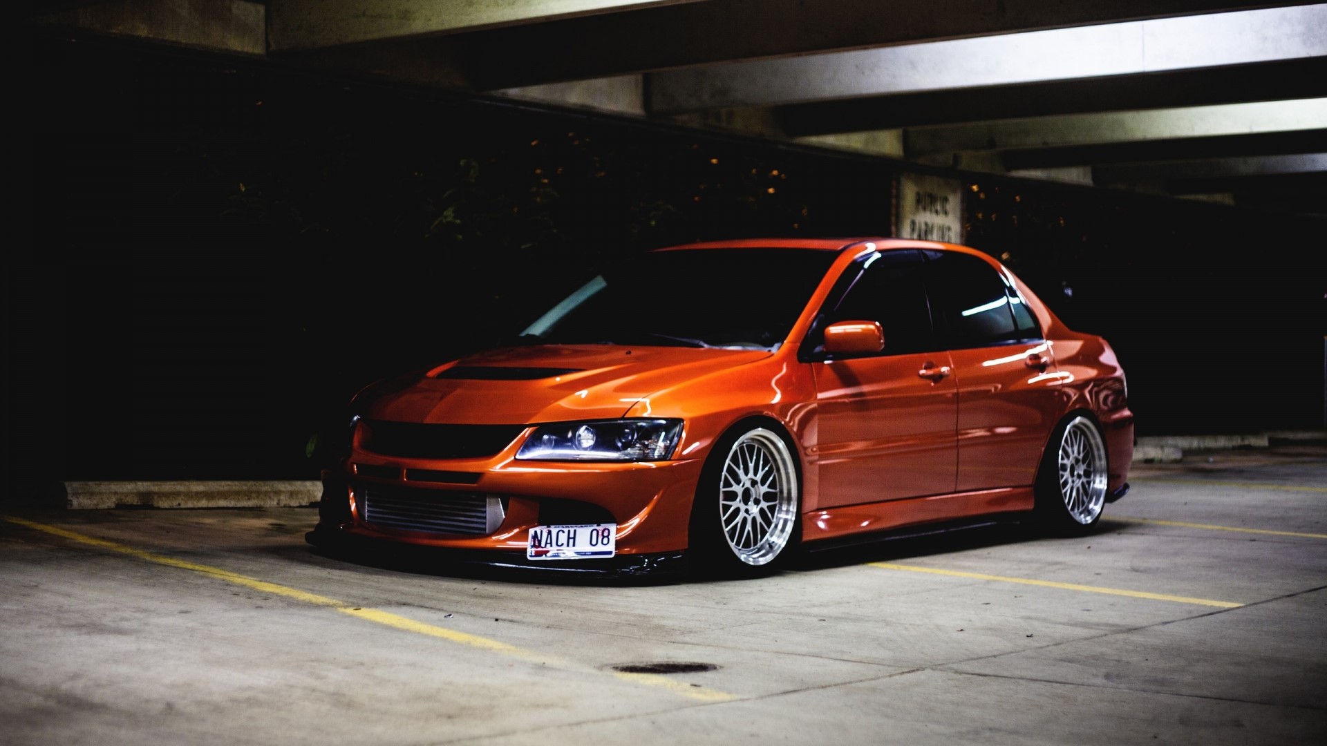 Orange Mitsubishi Lancer Evolution in parking garage HD Wallpaper