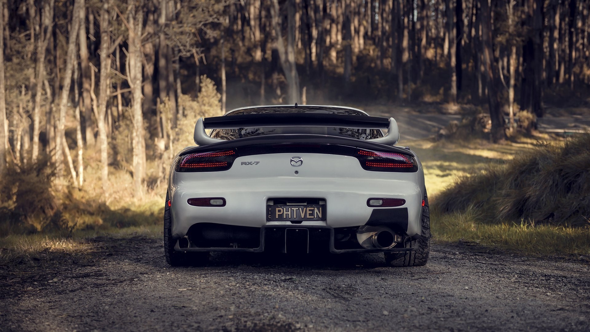 Mazda RX-7 parked on a dirt road in a forest HD Wallpaper