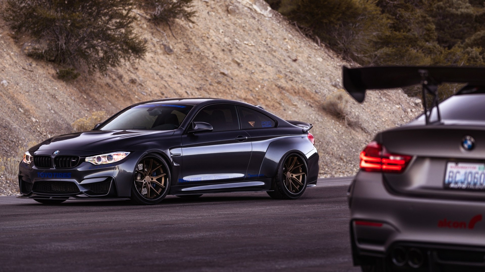 Two BMW M4 cars on a road HD Wallpaper
