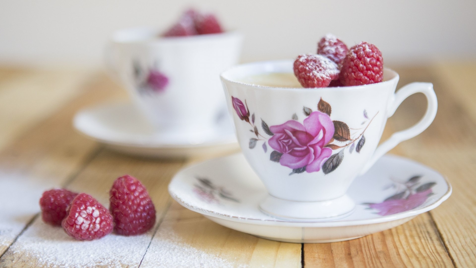 Two teacups with raspberries and powdered sugar HD Wallpaper