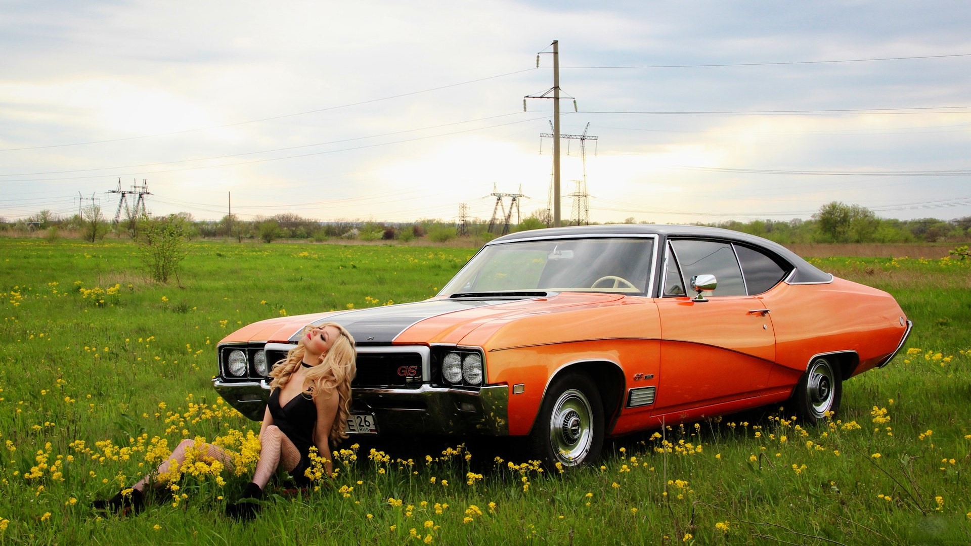 Woman in black dress with retro orange car in field HD Wallpaper
