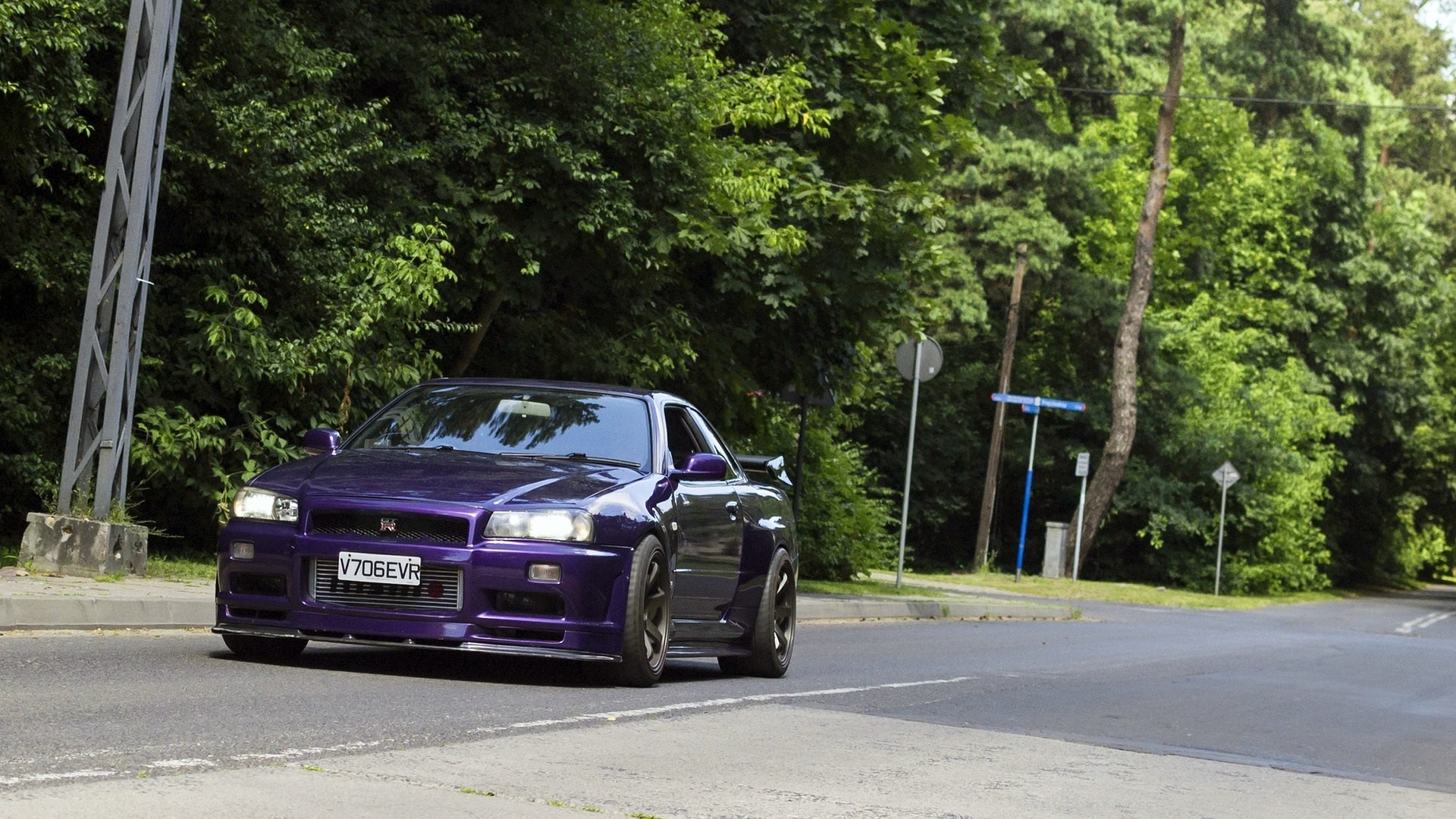 Purple Nissan Skyline R34 GTR driving on a road HD Wallpaper