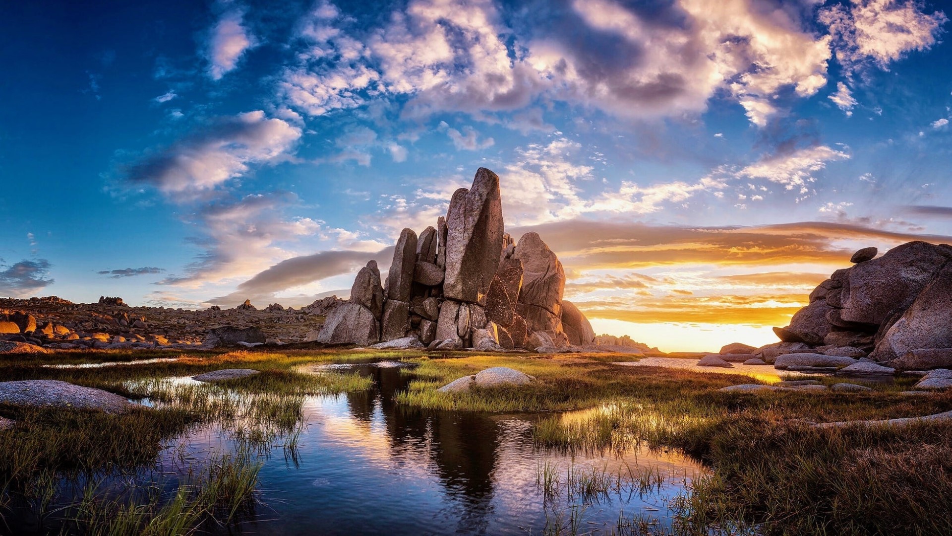Jagged rock formations in a desert landscape at sunset HD Wallpaper