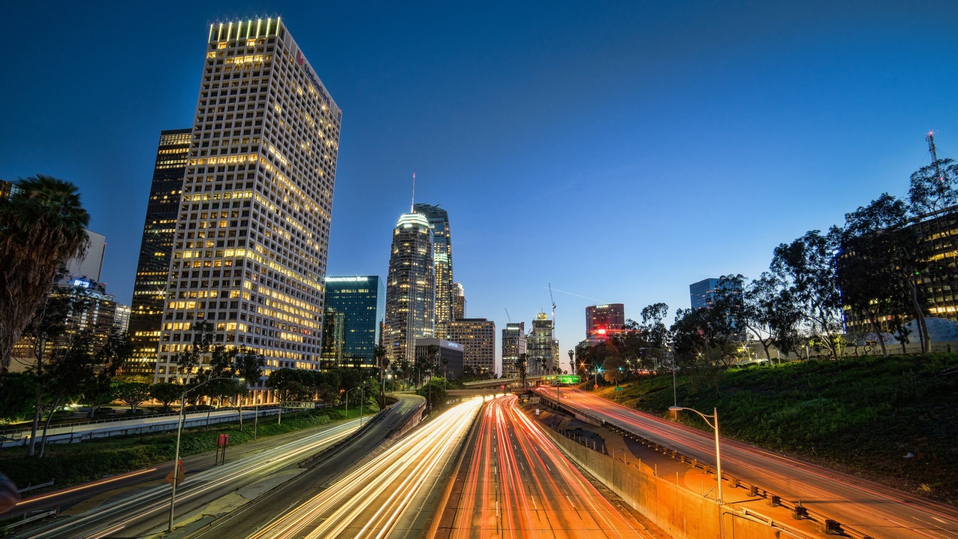 Los Angeles skyline with light trails on highway at dusk HD Wallpaper