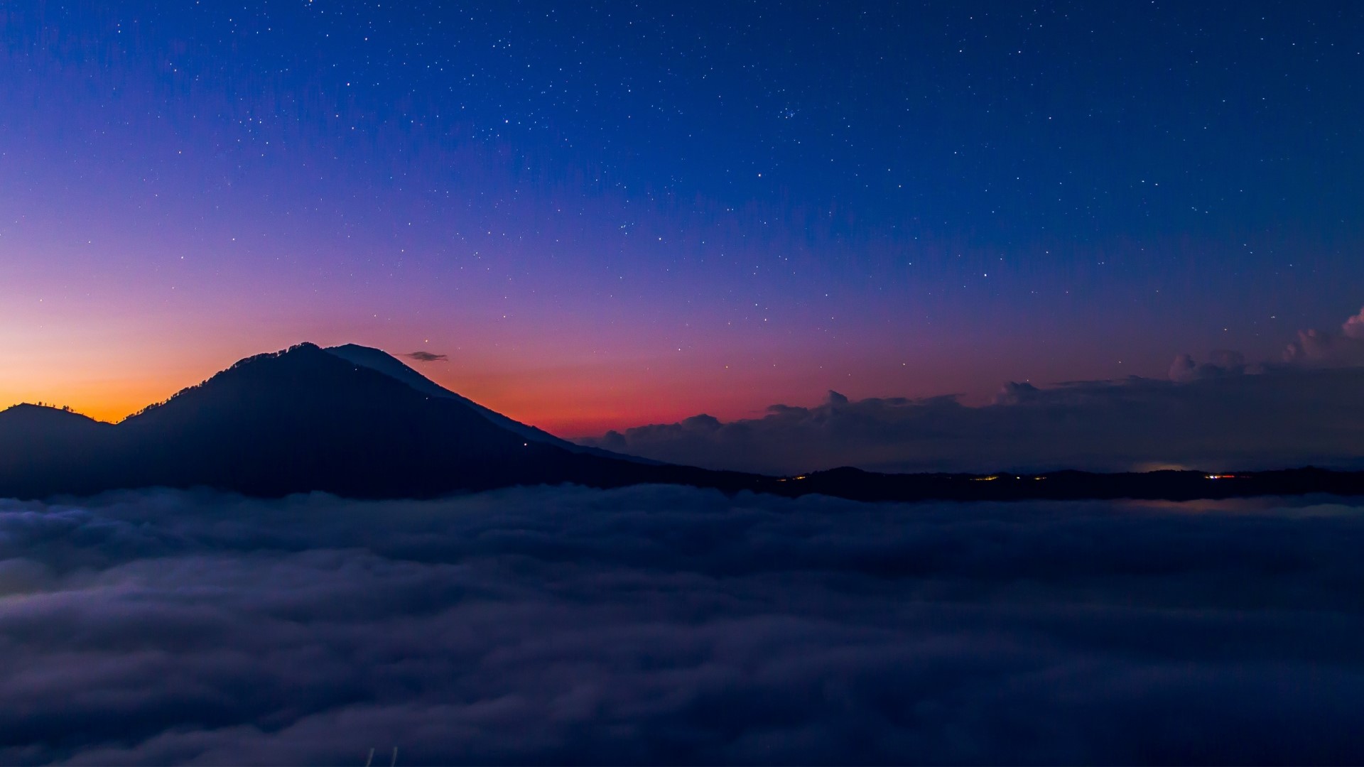 Mountain peak above clouds at twilight with stars HD Wallpaper