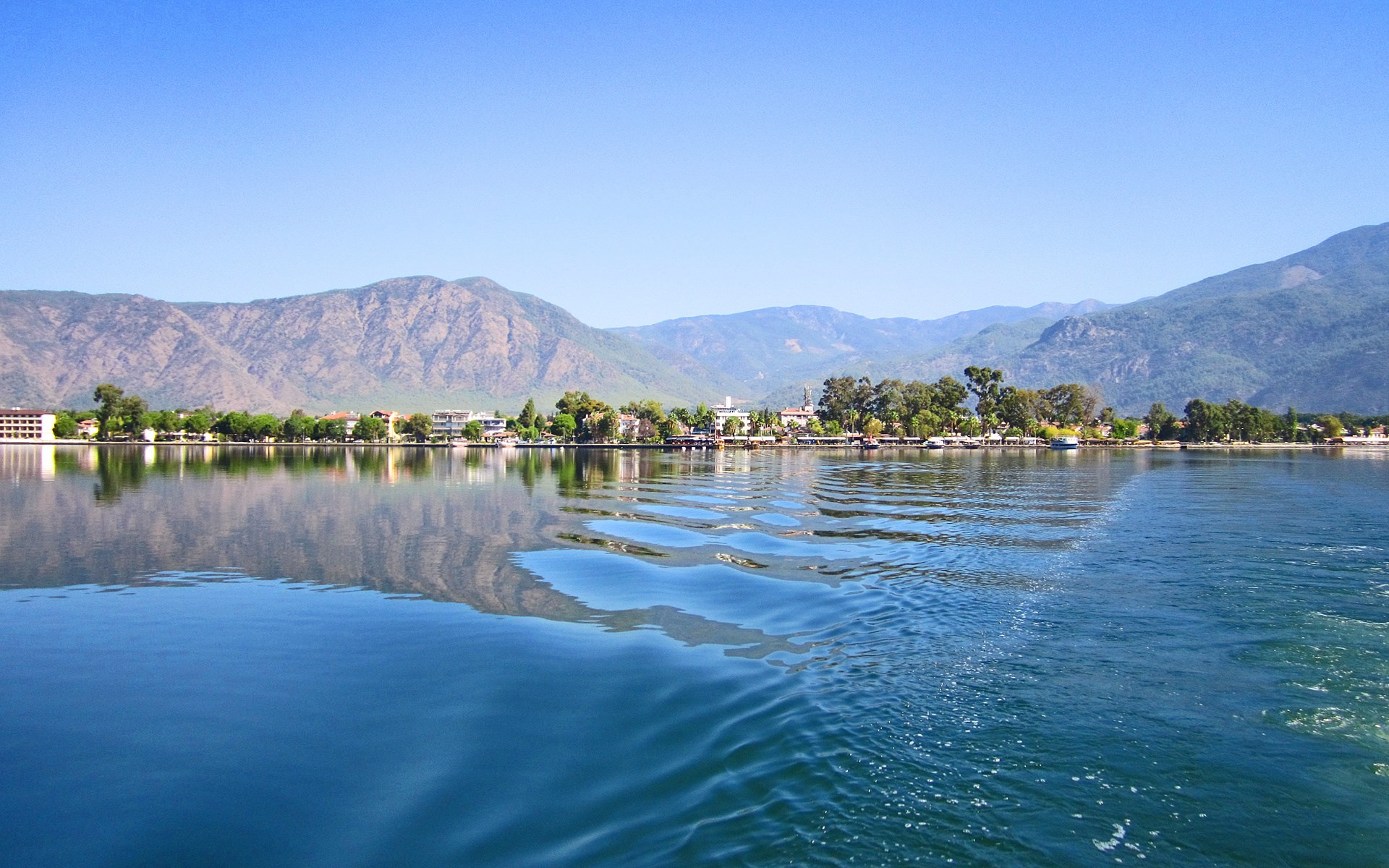 Town on a lake with mountains in the background HD Wallpaper