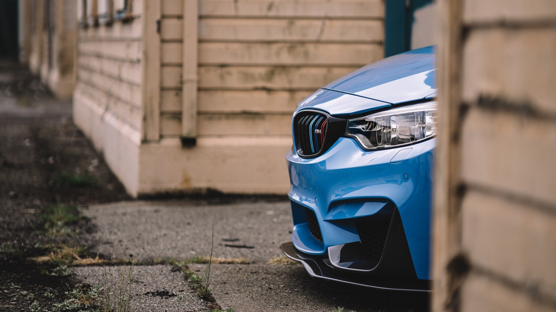 Blue BMW M4 parked near a building HD Wallpaper