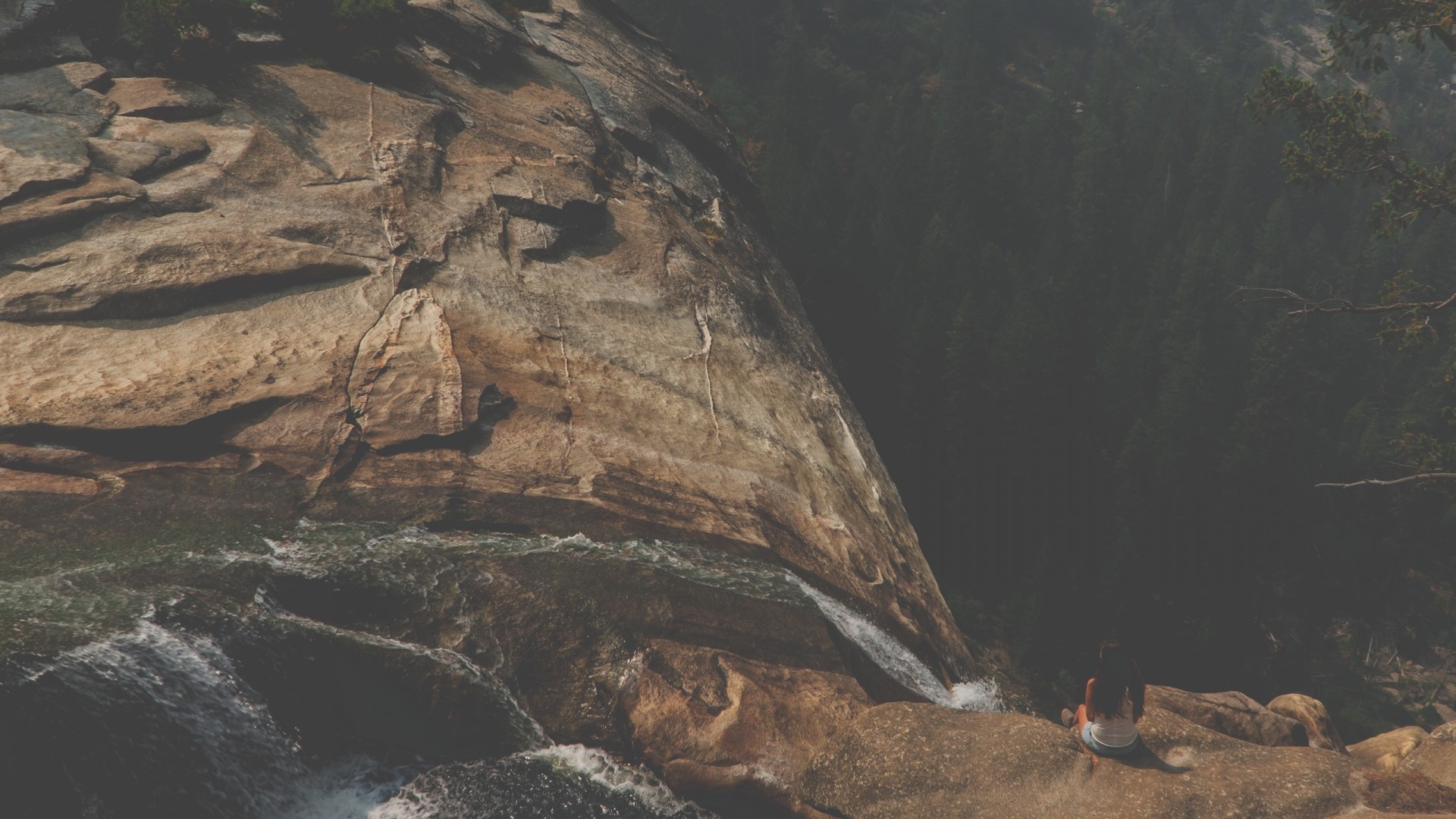 Girl sitting on a rock overlooking a waterfall HD Wallpaper