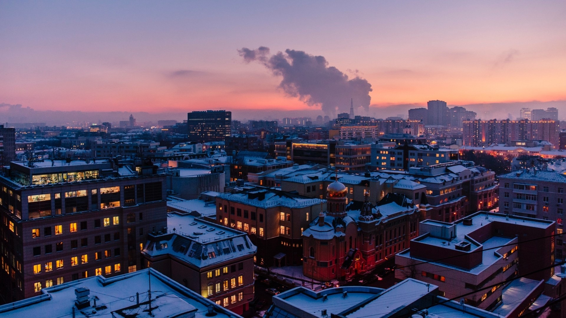 Cityscape at dusk with snow-covered roofs HD Wallpaper