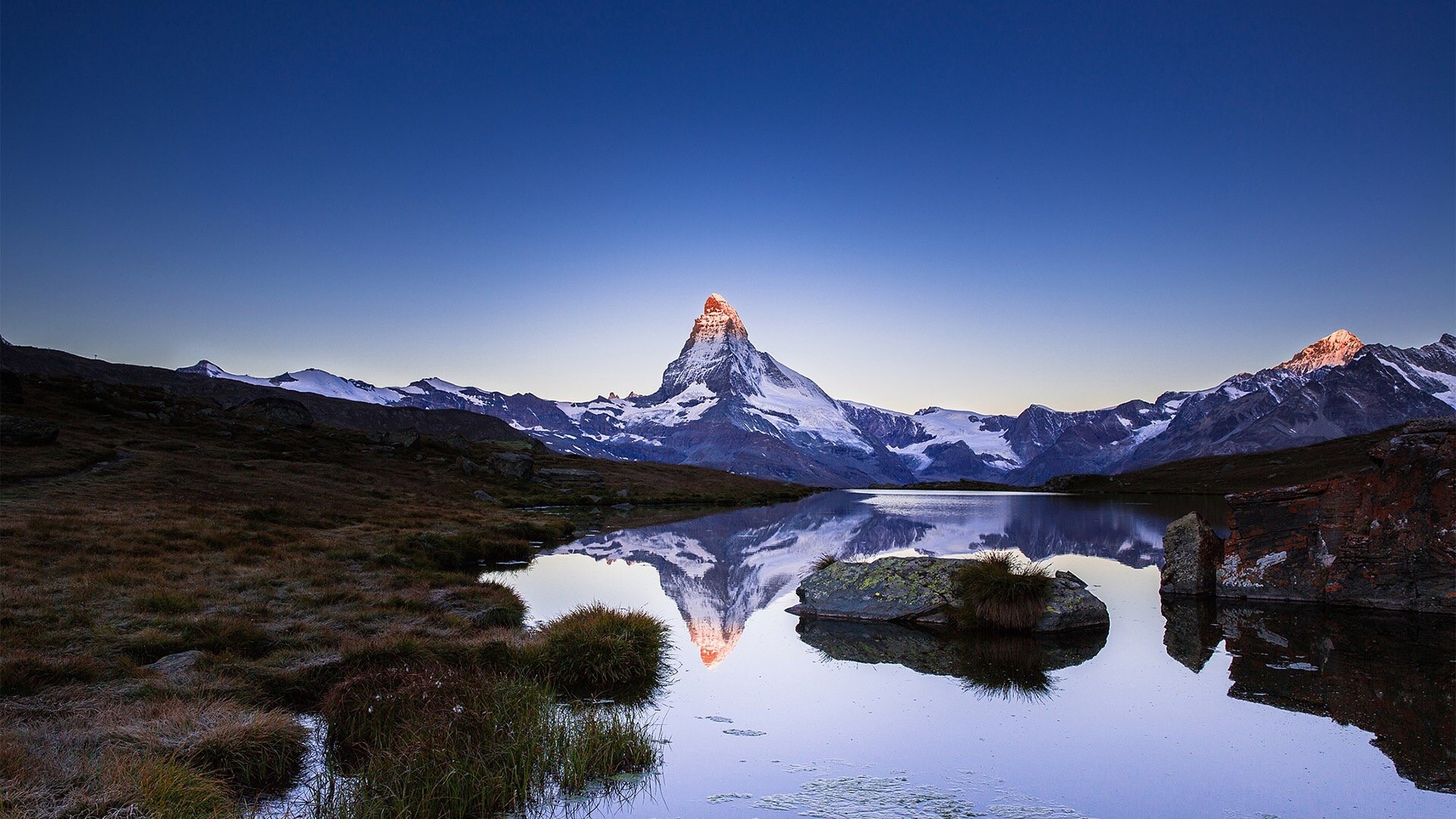 Matterhorn mountain reflected in a lake at sunrise HD Wallpaper