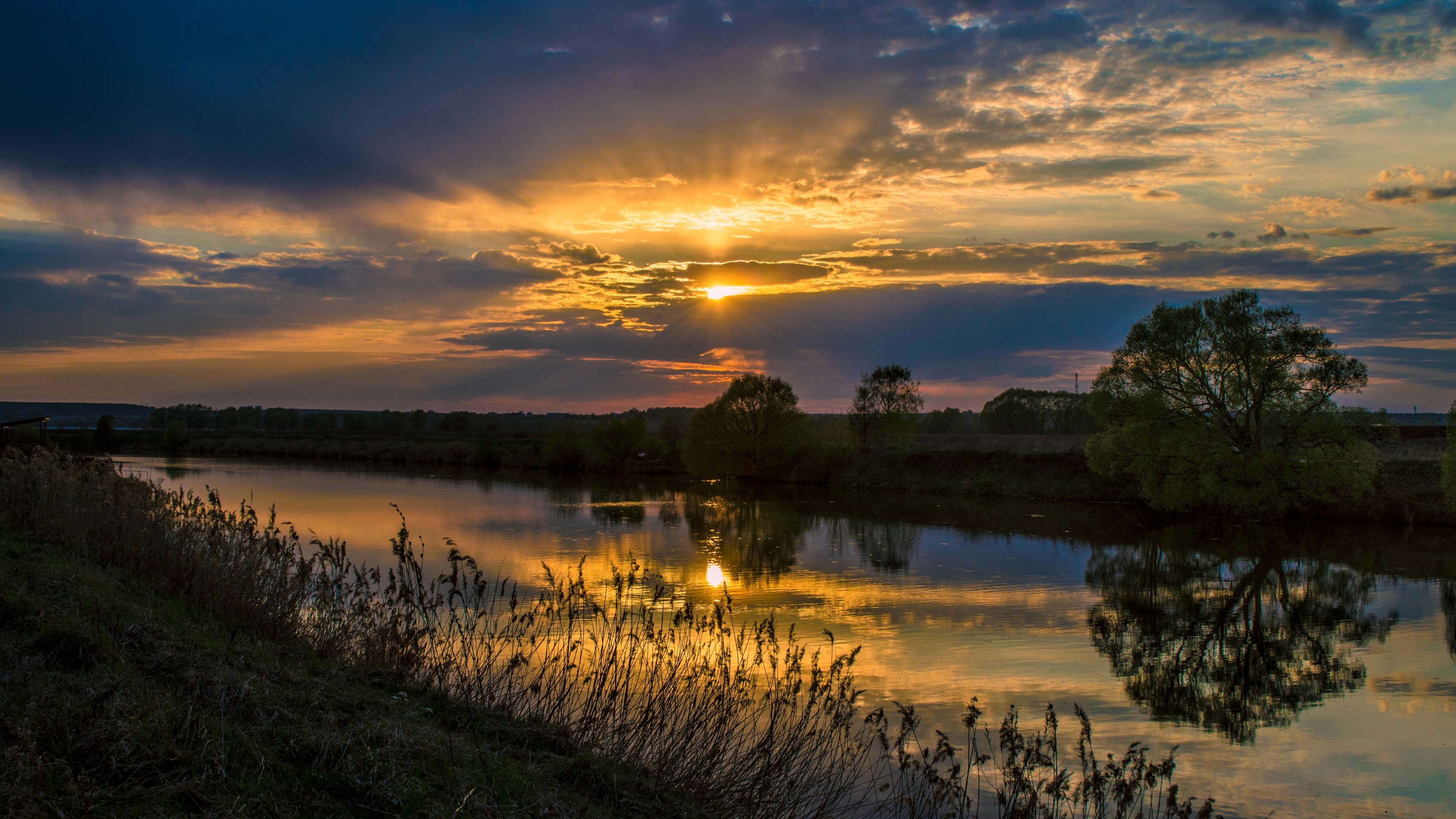 Sunset over a river with reflections HD Wallpaper