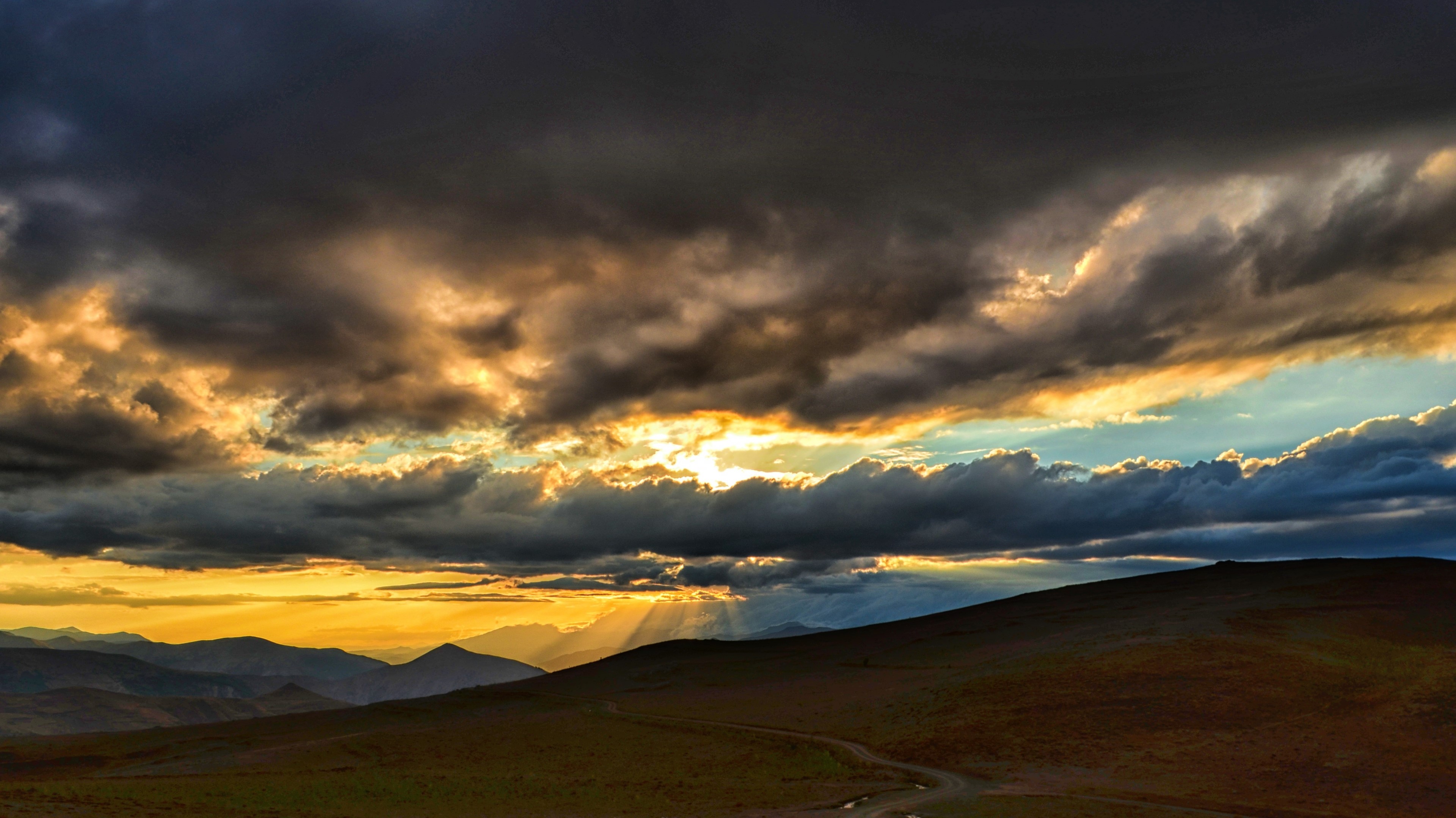Sunset over mountains with dramatic clouds HD Wallpaper