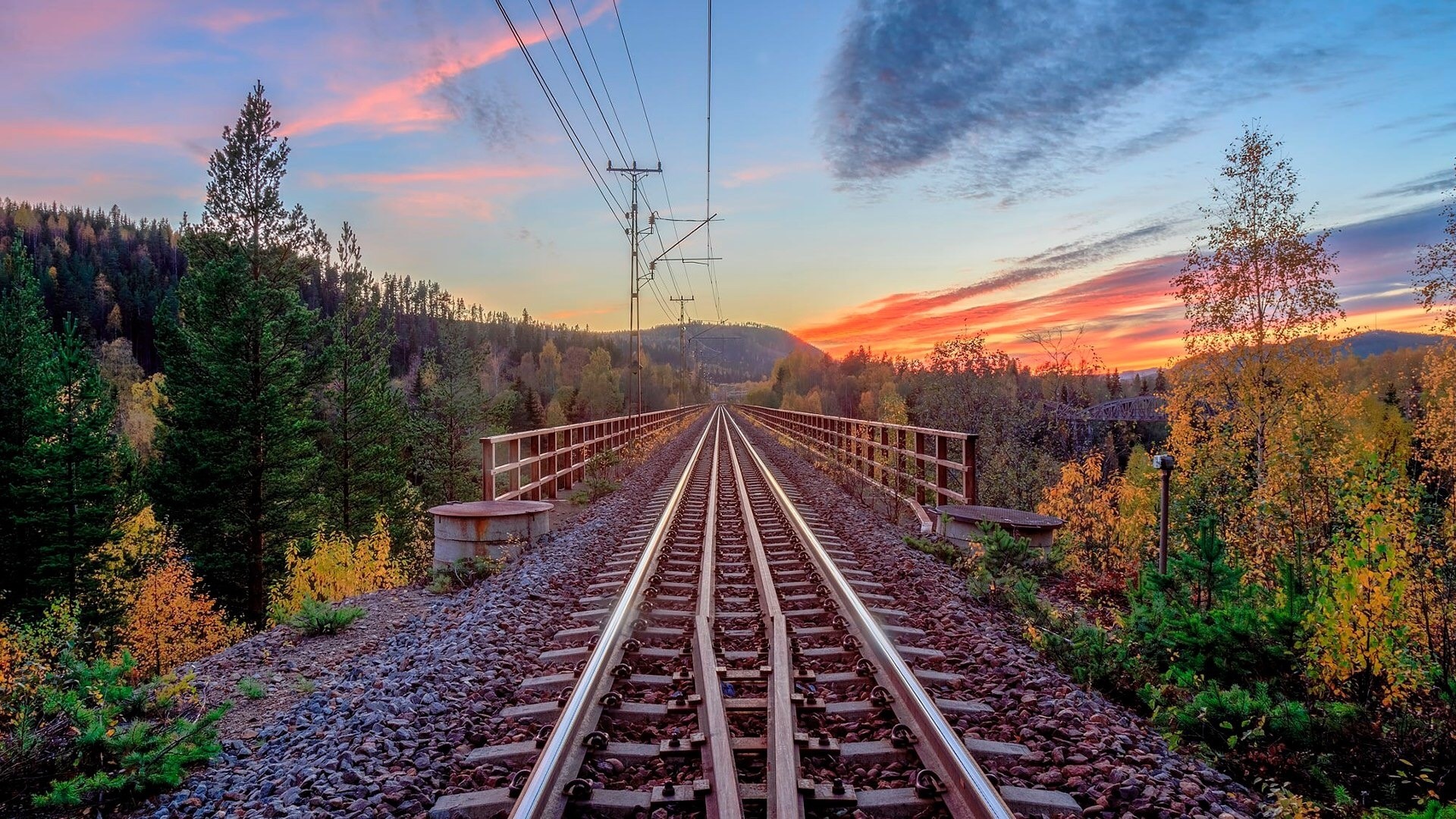 Train tracks on a bridge in Sweden at sunset HD Wallpaper