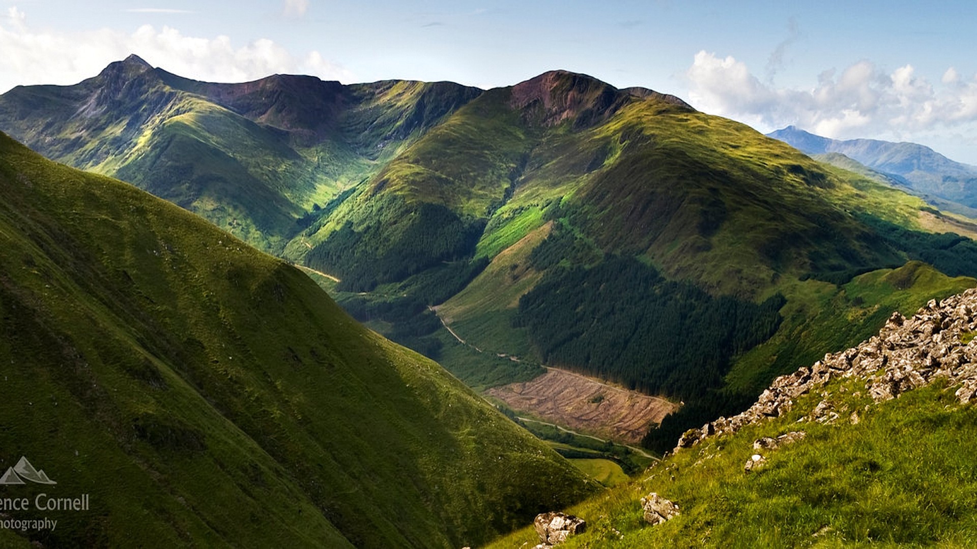 Green mountains under a cloudy sky HD Wallpaper