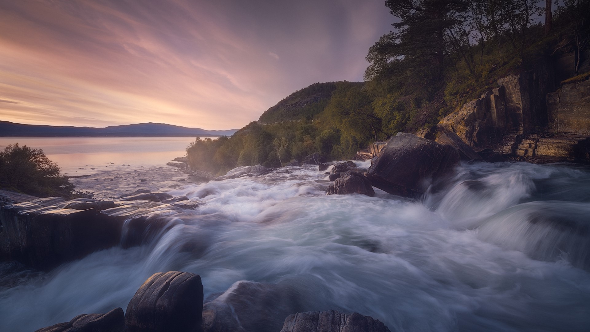 Waterfall flowing into a lake at sunset HD Wallpaper