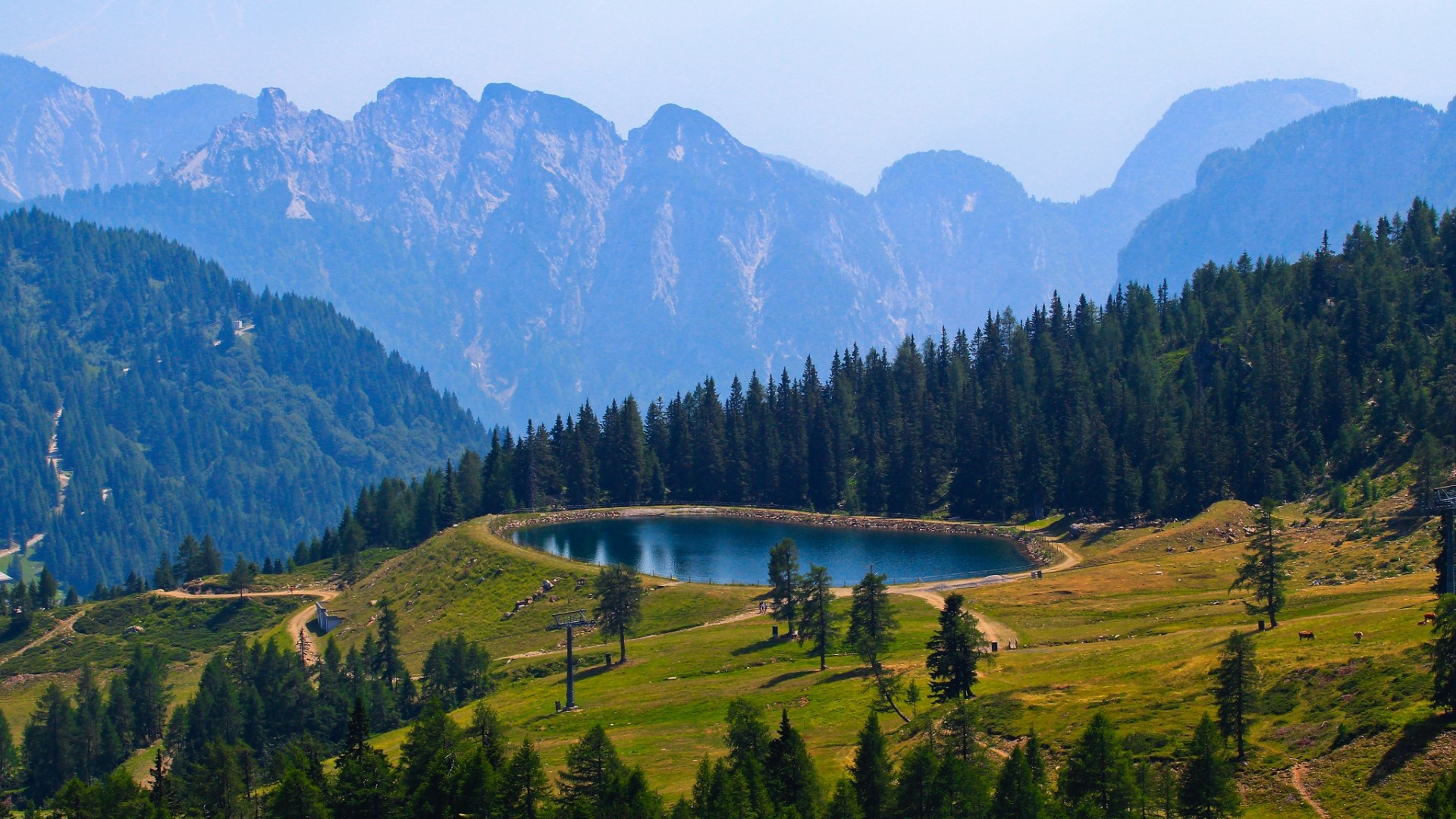Mountain lake surrounded by pine trees and rocky peaks HD Wallpaper