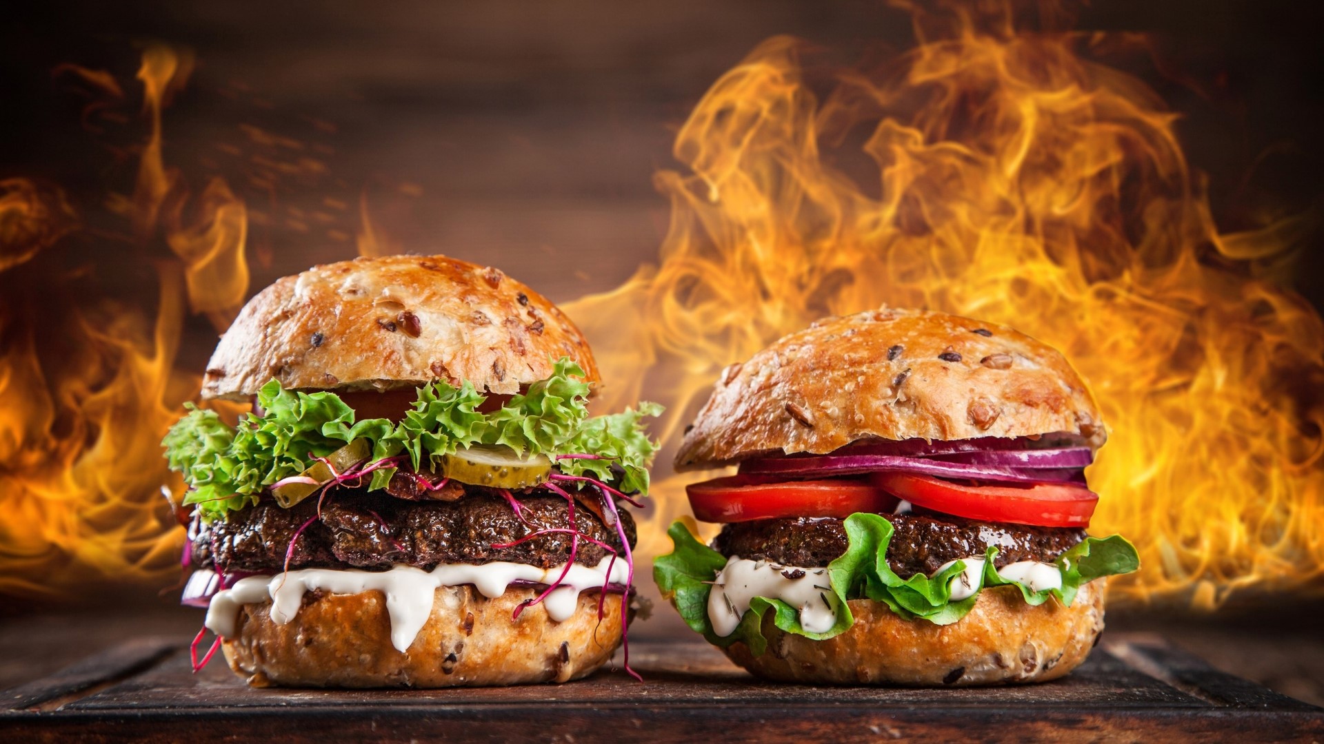 Two gourmet burgers with flames in the background HD Wallpaper