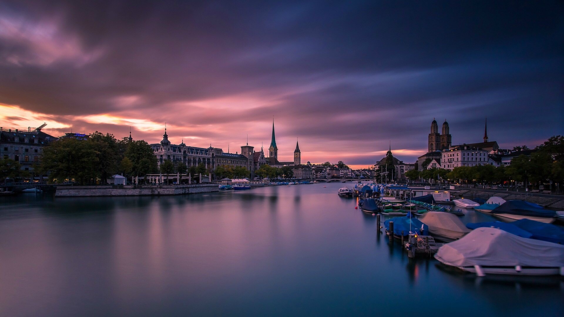 Zurich cityscape with river and boats at sunset HD Wallpaper