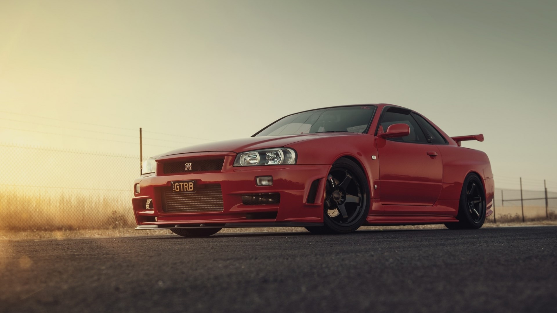 Red Nissan GT-R R34 on asphalt HD Wallpaper
