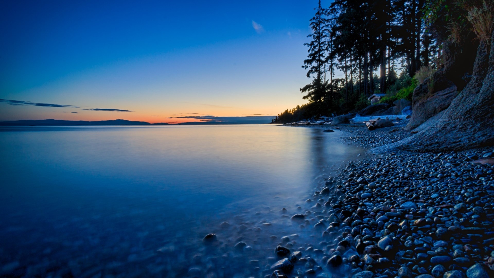 Twilight over a rocky beach and forest HD Wallpaper