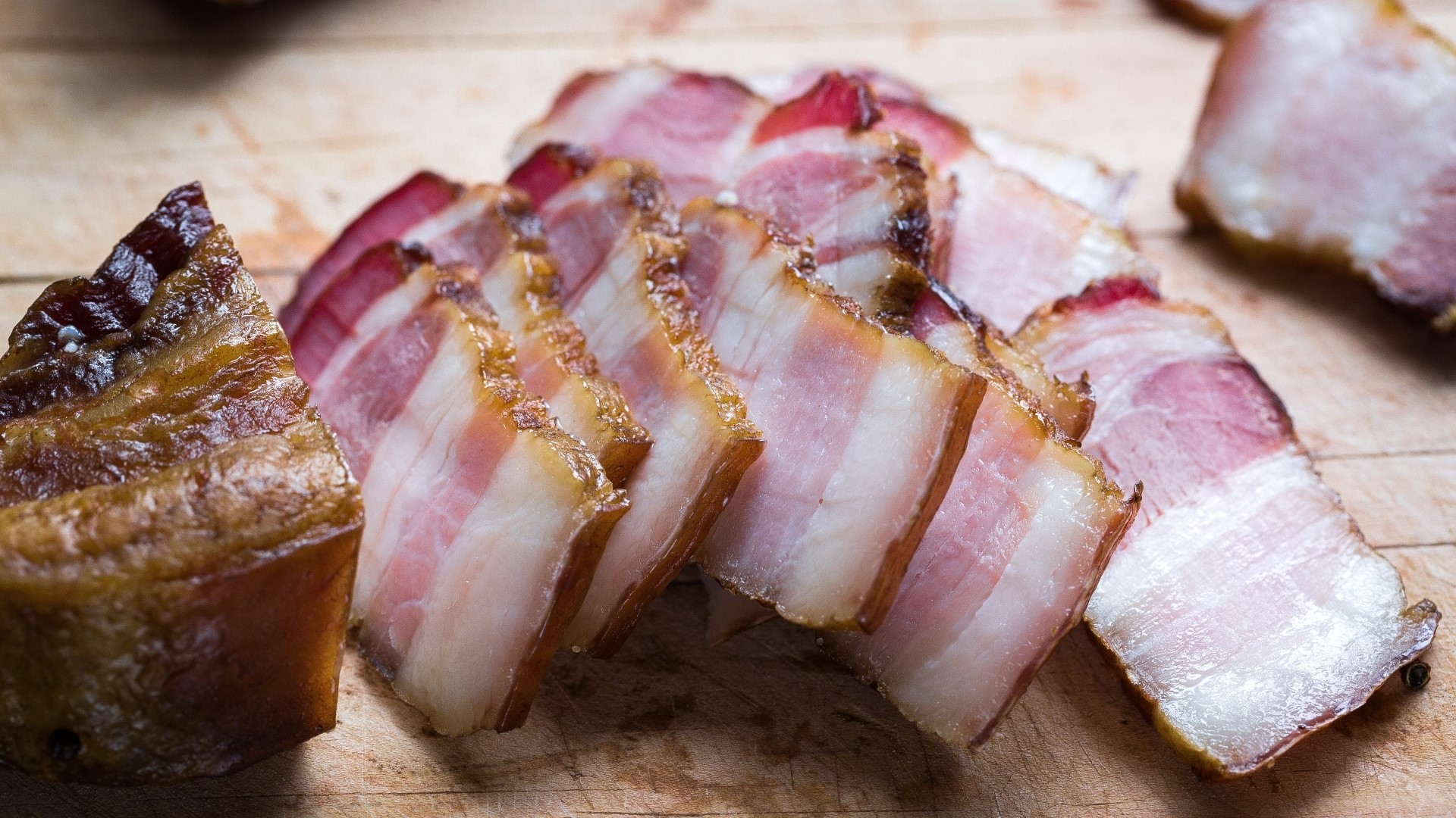 Slices of smoked bacon on a wooden board HD Wallpaper