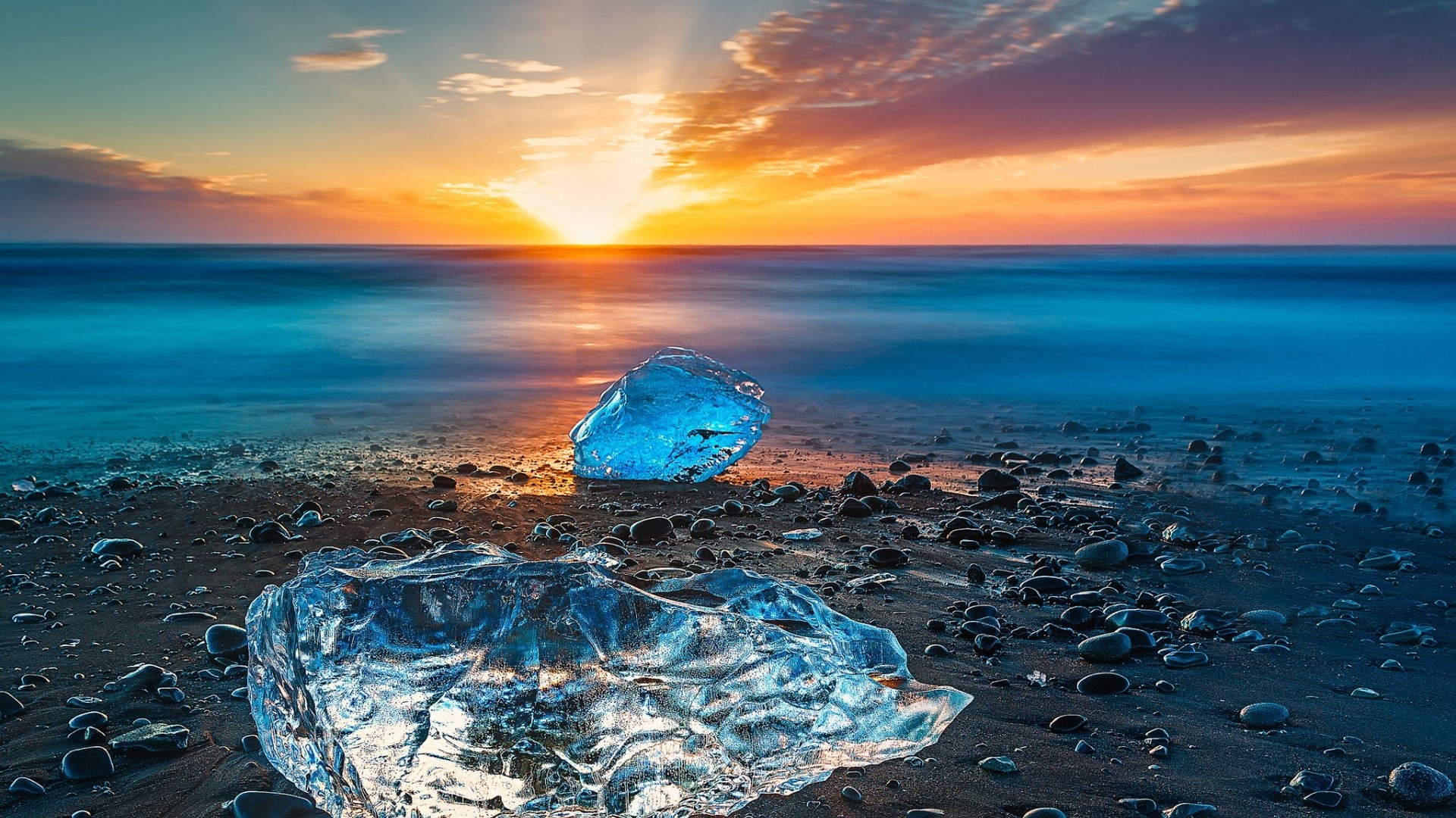 Ice chunks on a beach at sunset HD Wallpaper