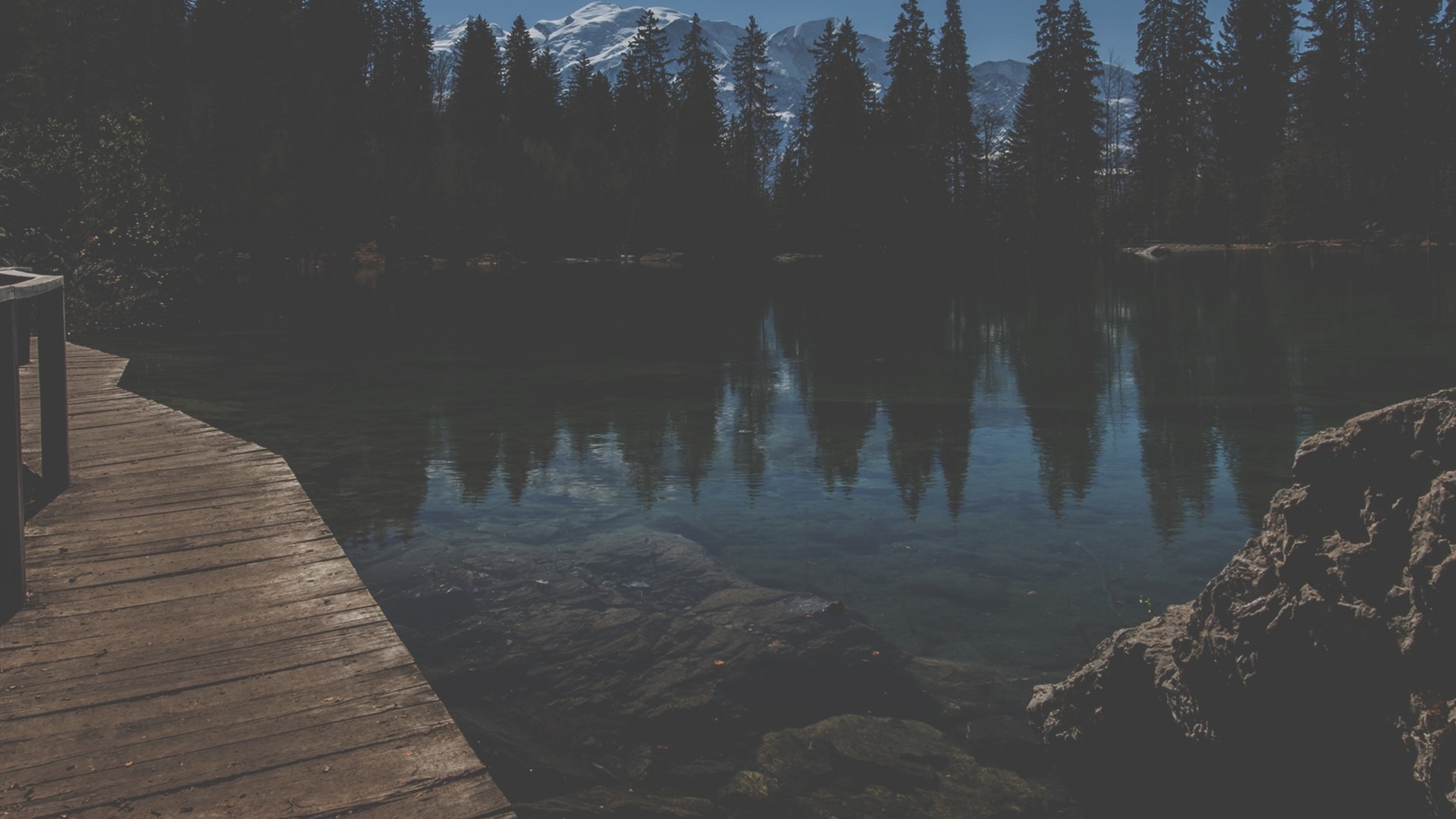 Wooden walkway by a lake with mountains and forest HD Wallpaper