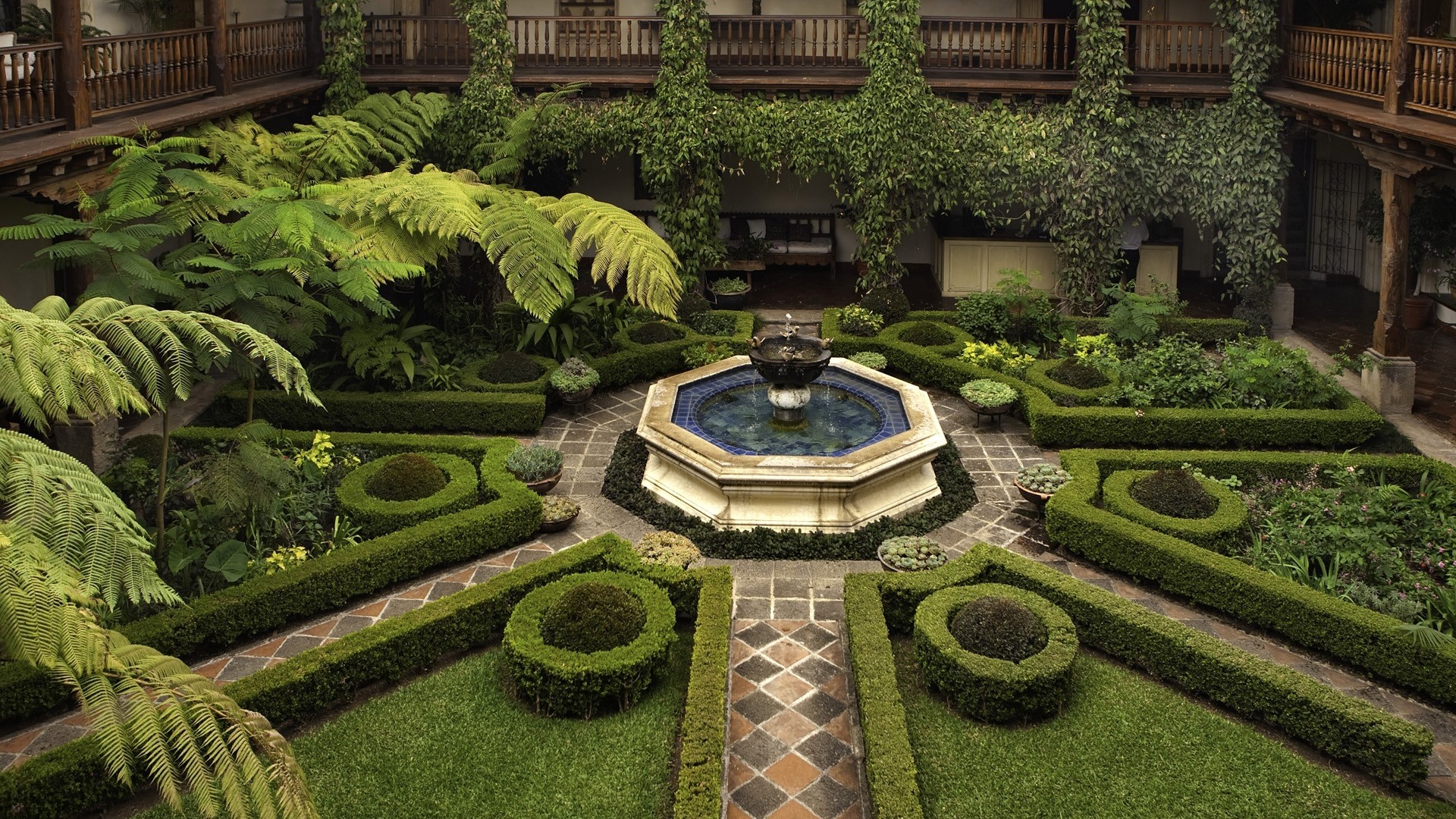 Courtyard garden with octagonal fountain and manicured hedges HD Wallpaper