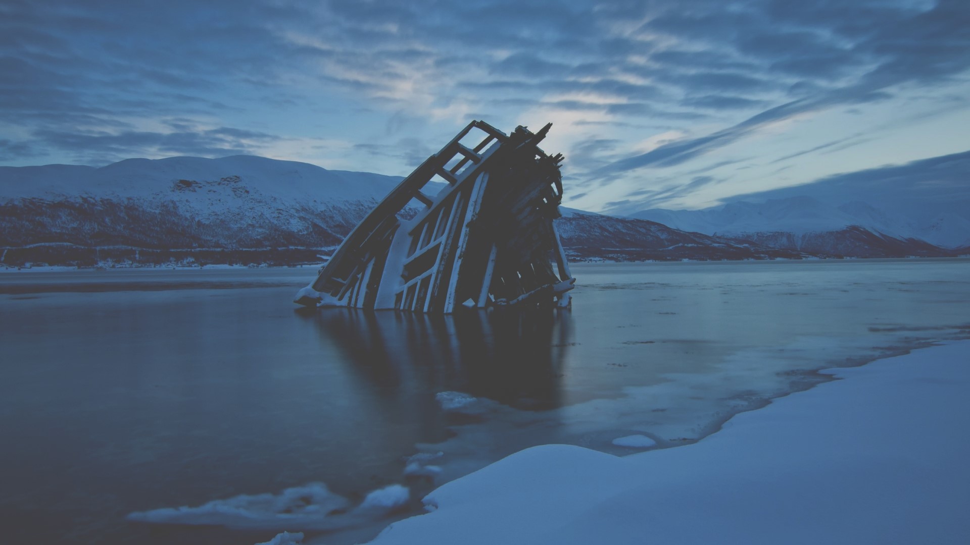 Frozen shipwreck in a snowy landscape HD Wallpaper