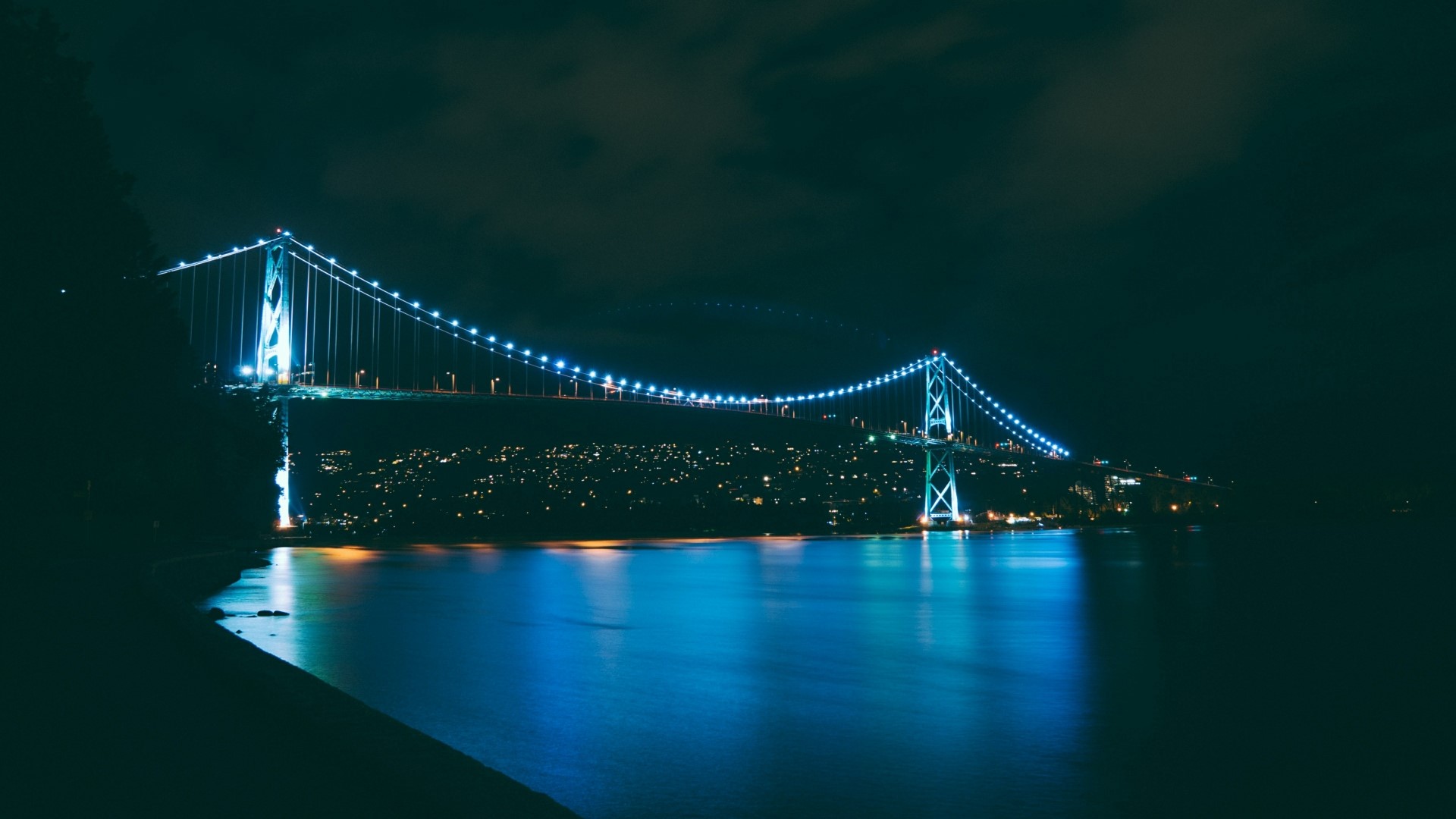 Night view of Lions Gate Bridge illuminated with blue lights HD Wallpaper