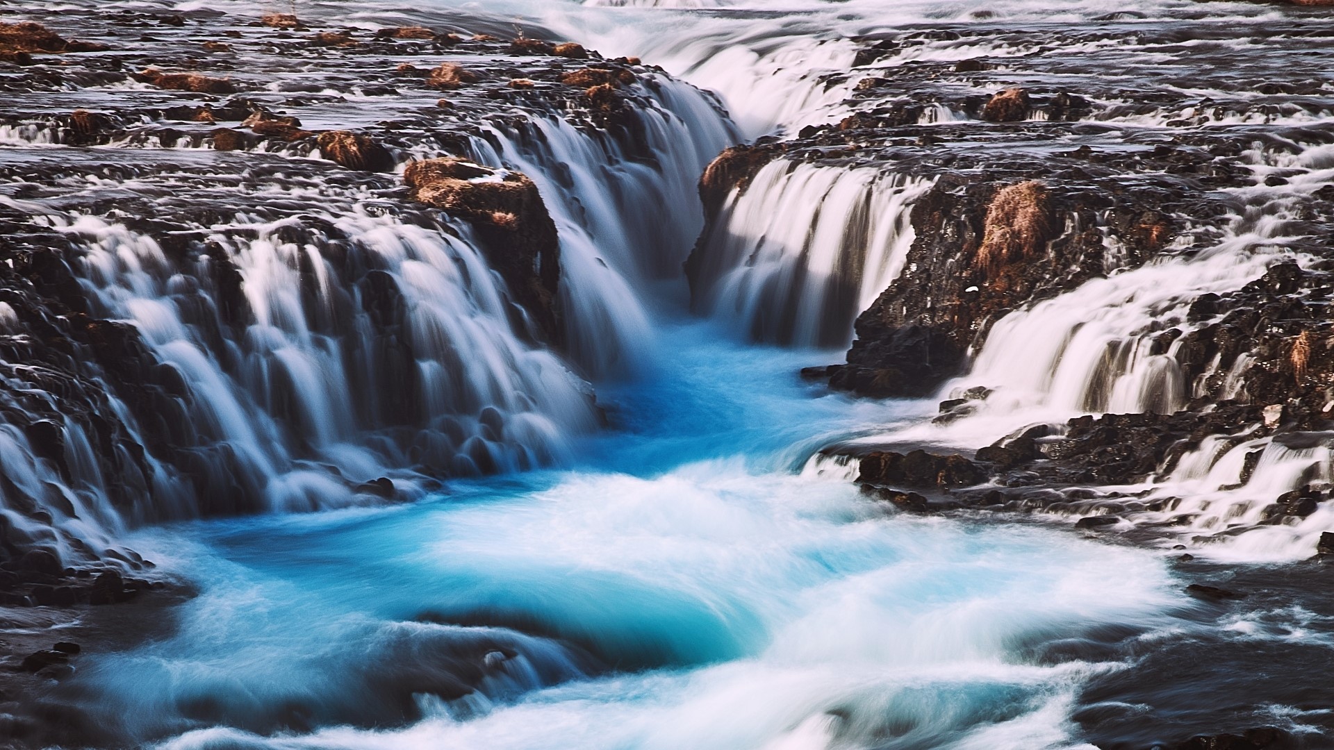 Blue cracked stream waterfall over dark rocks HD Wallpaper