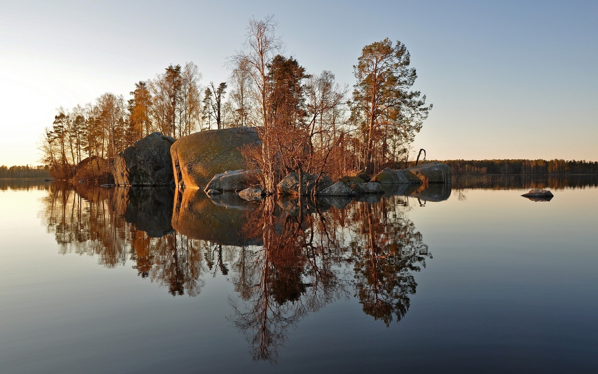 Island with trees and rocks reflected in water HD Wallpaper