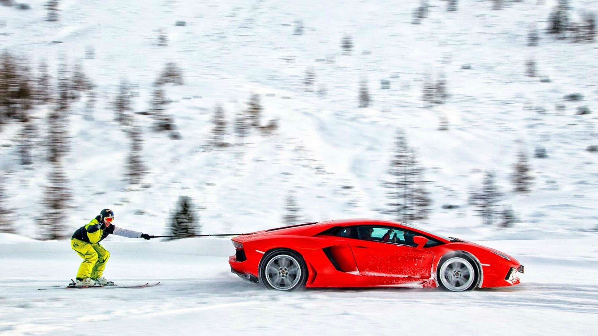 Skier being pulled by a red Lamborghini Aventador in snow HD Wallpaper
