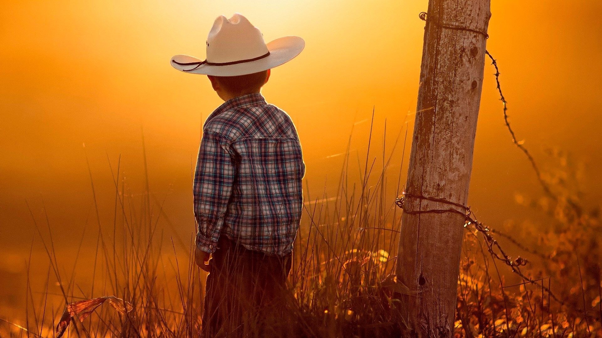 Little cowboy in a hat at sunset HD Wallpaper