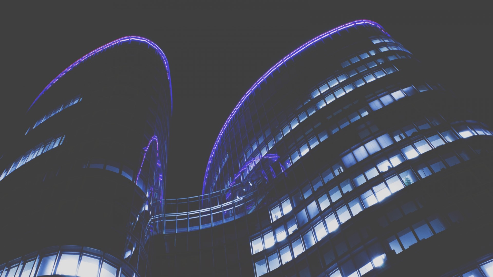 Modern building with purple and blue lights at night HD Wallpaper