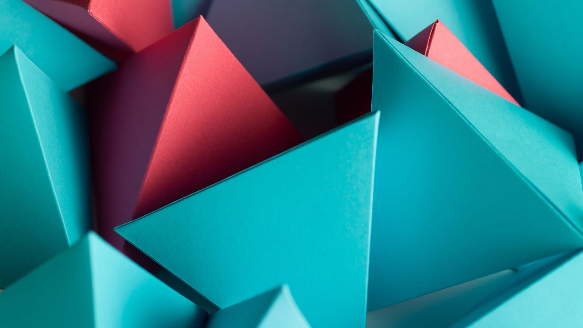 Abstract geometric arrangement of red and teal paper triangles HD Wallpaper