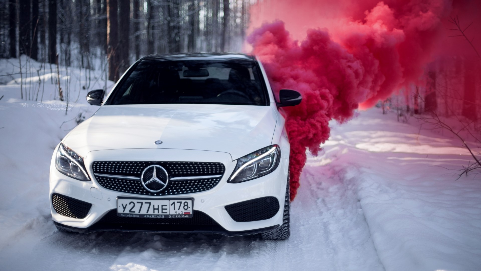 White Mercedes-Benz C450 AMG with red smoke in snow HD Wallpaper