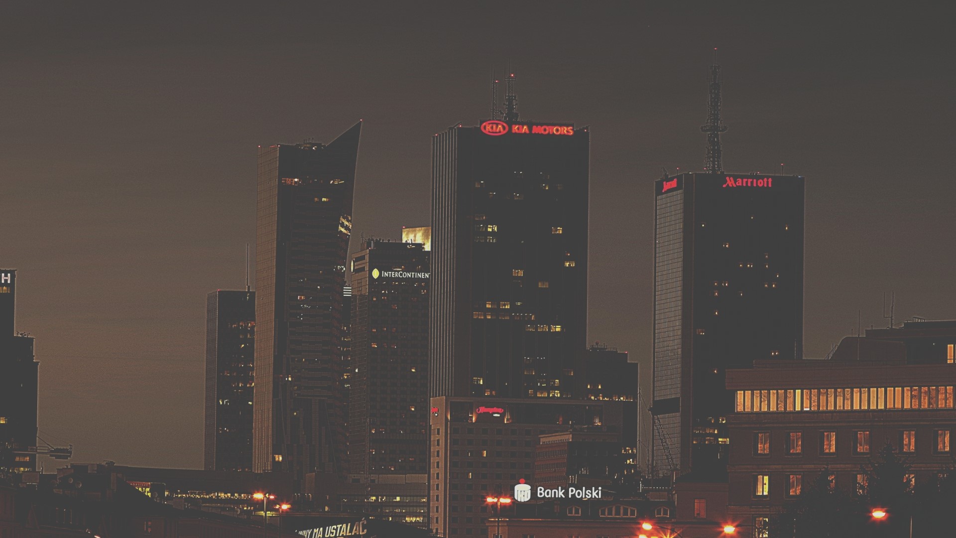 Night cityscape with illuminated skyscrapers and corporate logos HD Wallpaper