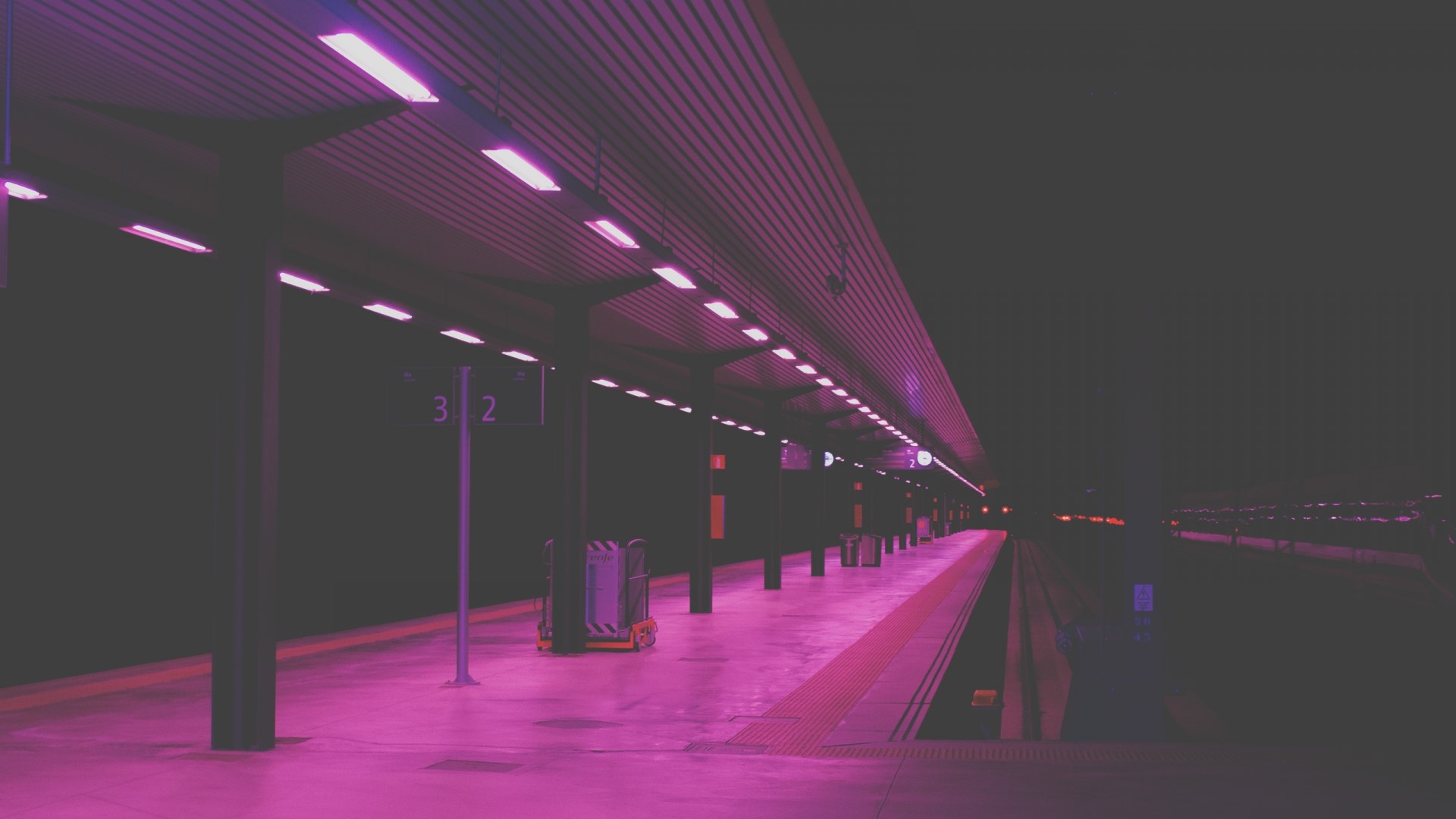 Empty train station platform at night with pink lights HD Wallpaper