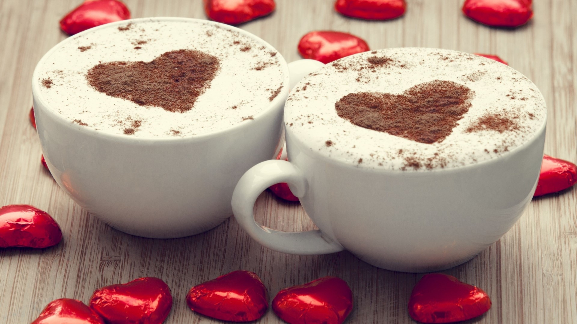 Two cups of coffee with heart art and chocolates HD Wallpaper