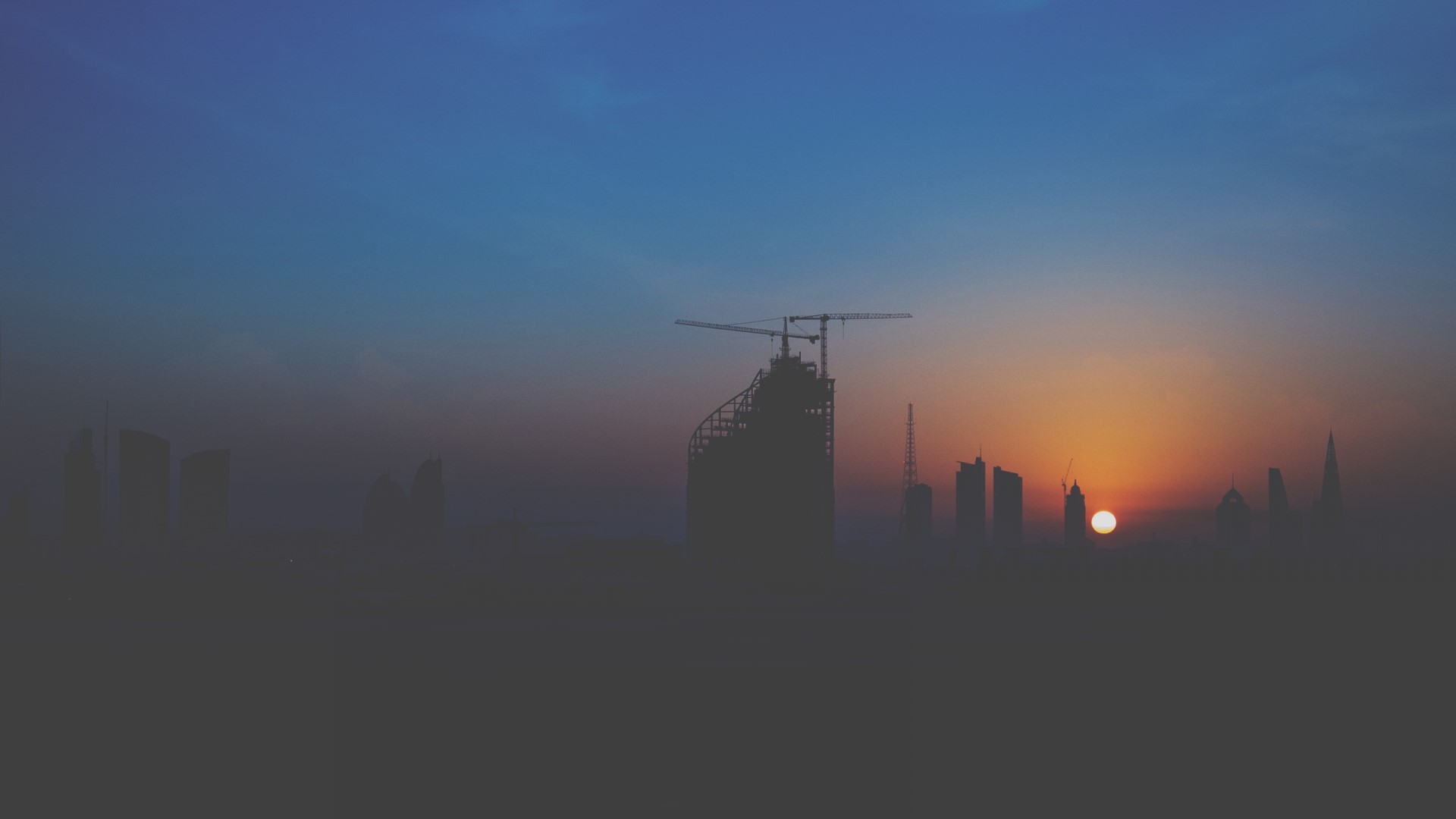 Dubai skyline at sunset with construction cranes HD Wallpaper