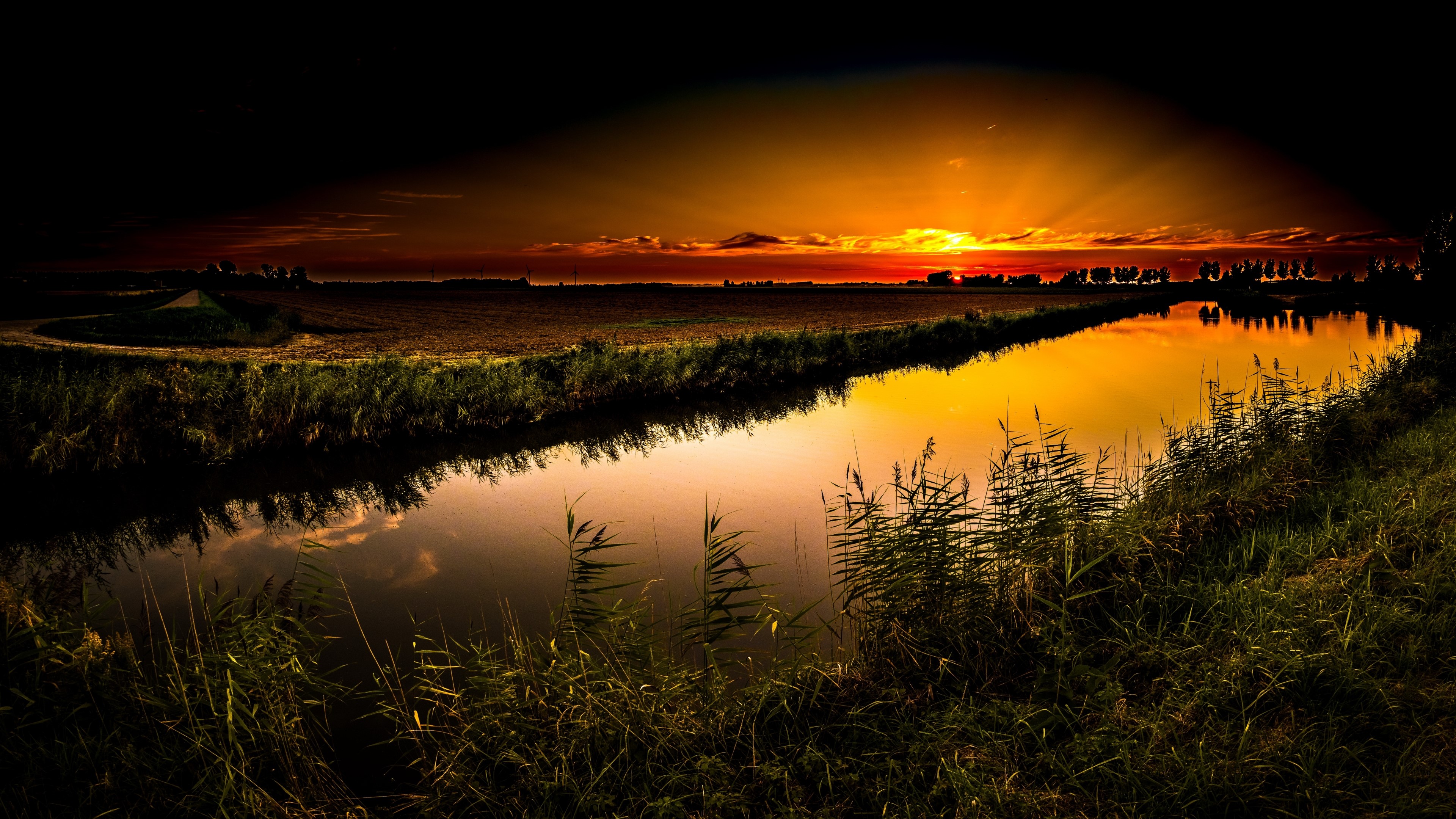 Sunset over a canal with reeds and fields HD Wallpaper