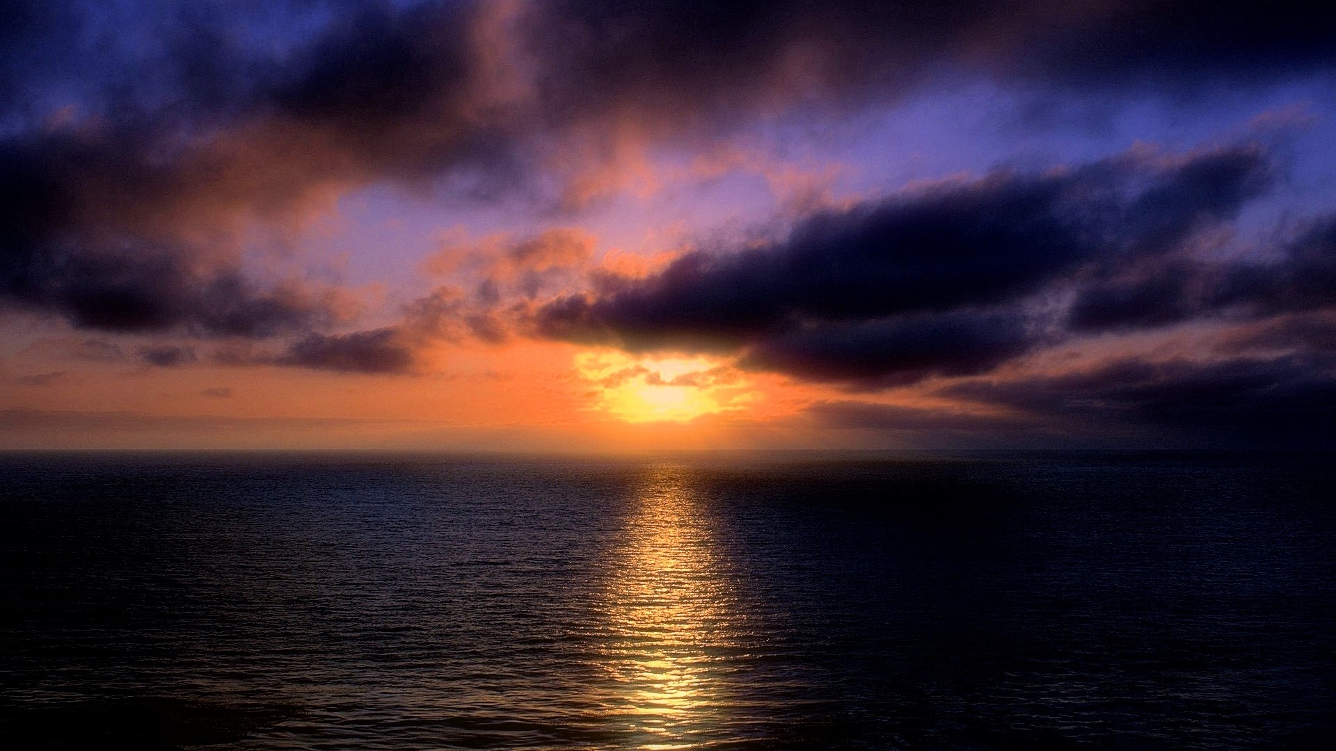 Sunset over the ocean with dramatic clouds HD Wallpaper