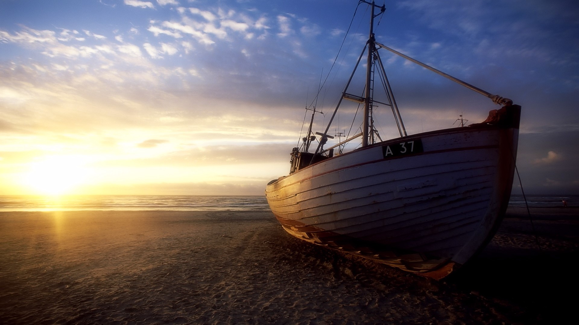 Fishing boat on a beach at sunset HD Wallpaper