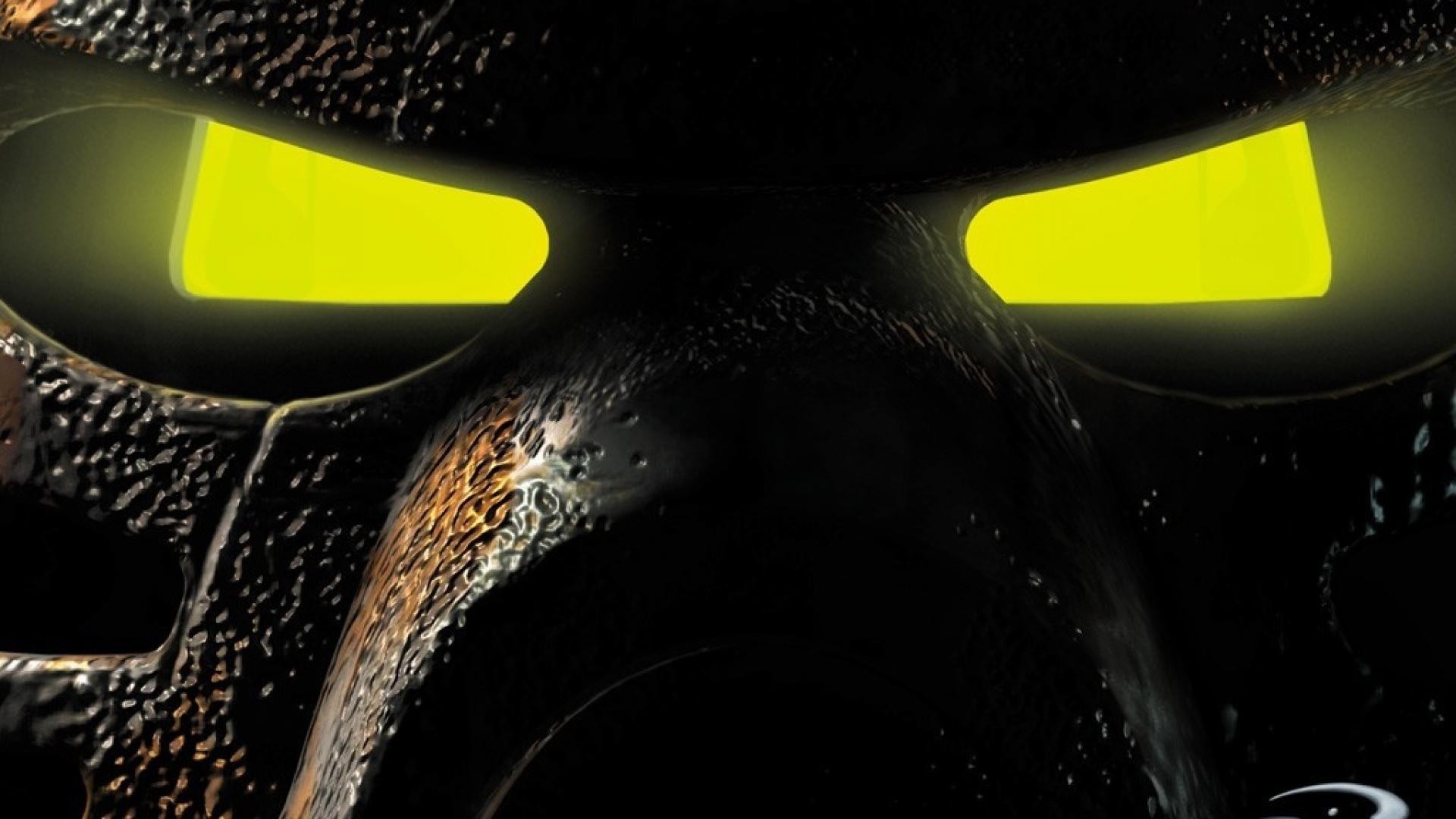 Close-up of a Bionicle mask with glowing yellow eyes HD Wallpaper