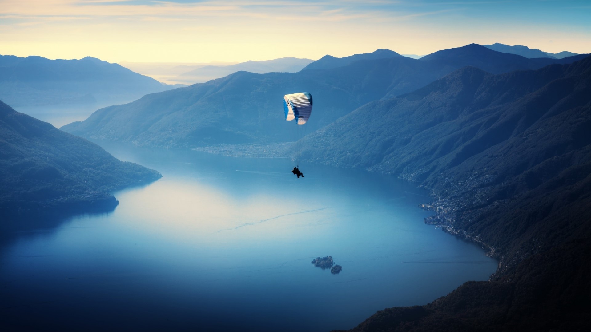Paraglider over a lake and mountains HD Wallpaper