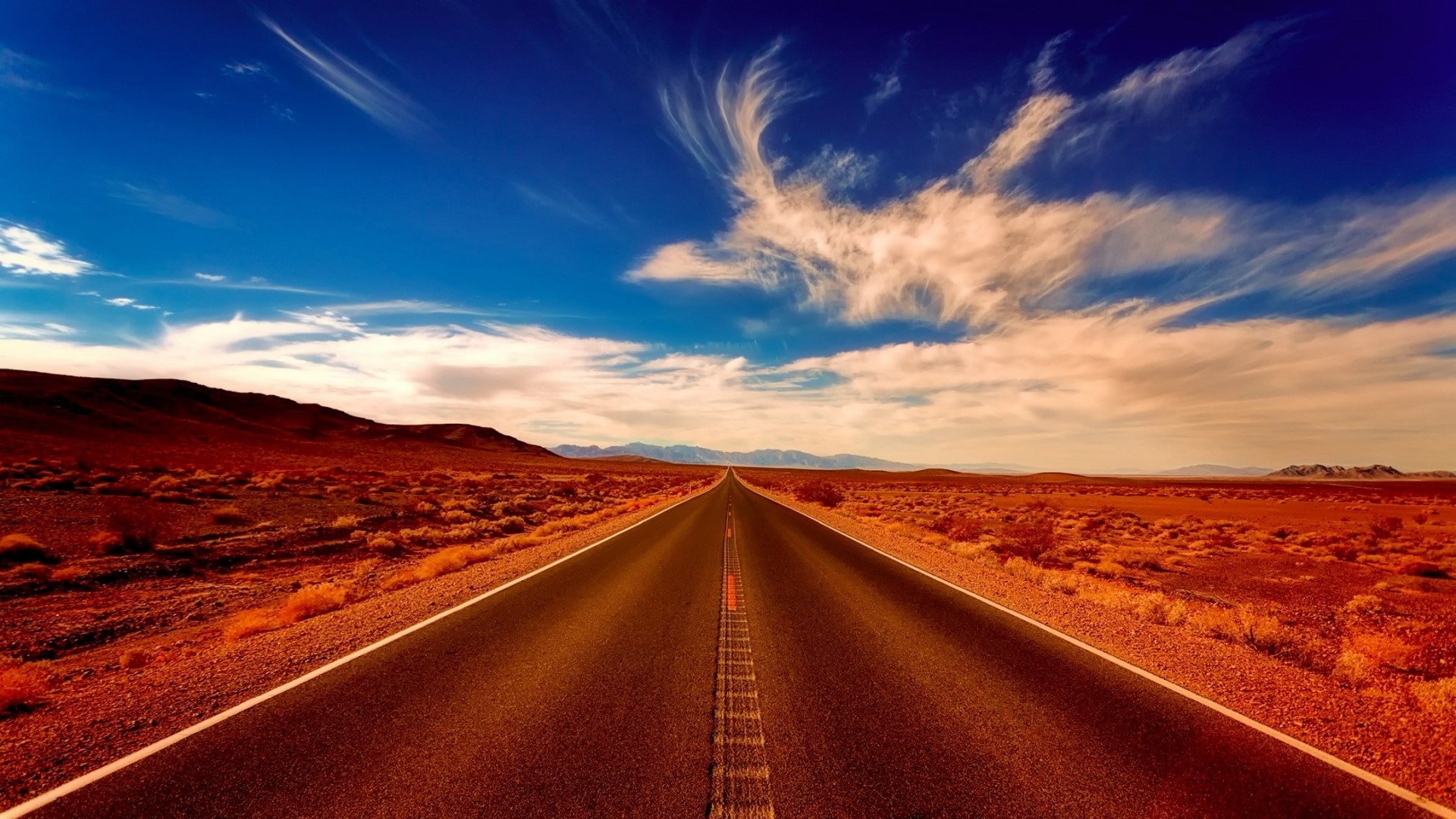 Desert road under a blue sky HD Wallpaper