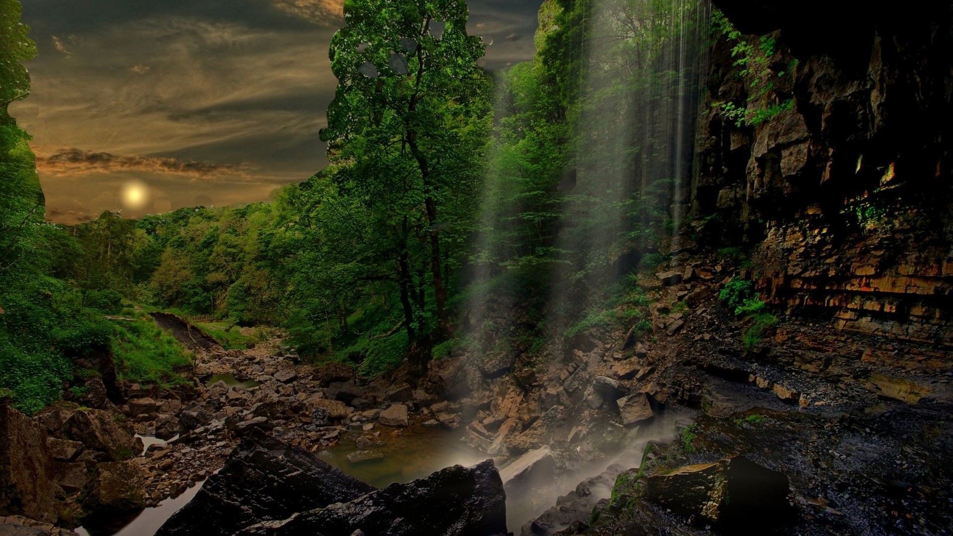 Waterfall in a lush green forest with a dramatic sky HD Wallpaper