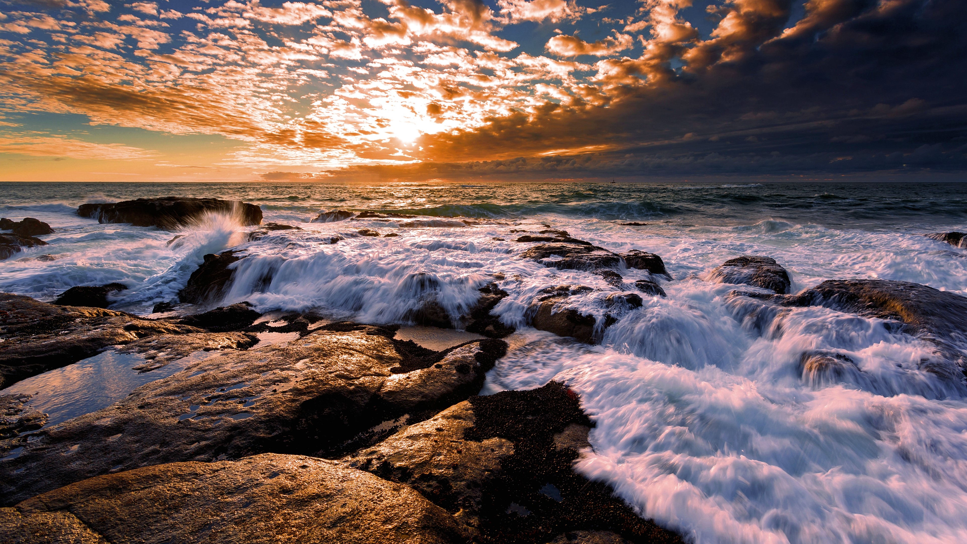 Waves crashing on rocky shore at sunset HD Wallpaper